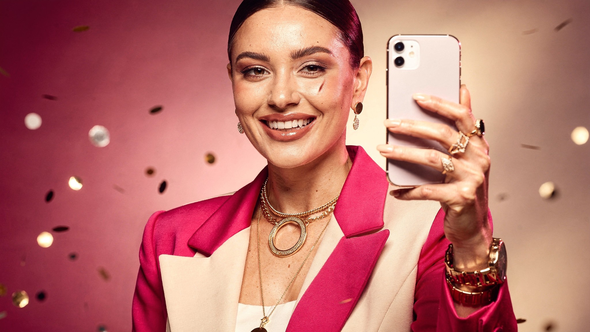 Adult creator holding up her phone with a bright smile after posting a carousel