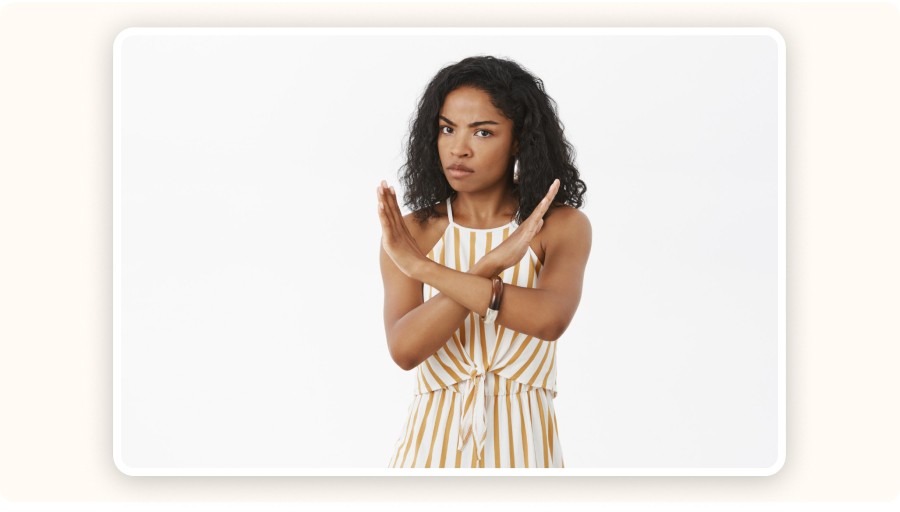 Woman making stop gesture with crossed arms and serious expression