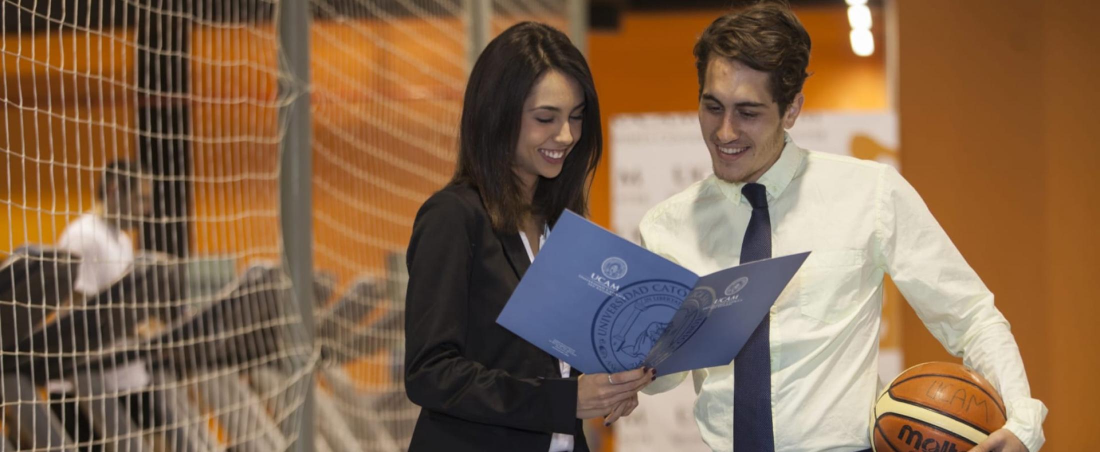 A group of young adults collaborate around laptops in a modern, well-lit office space, engaging in a productive discussion at European UCAM University.