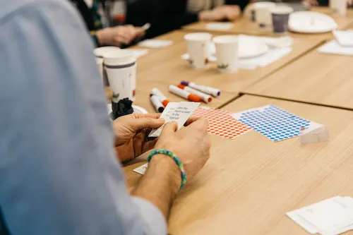 People working on art paper at a table.