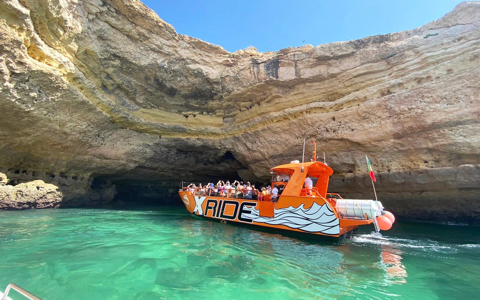 Barco entrando na caverna marinha no tour X Ride Dolphin and Caves, na costa do Algarve.