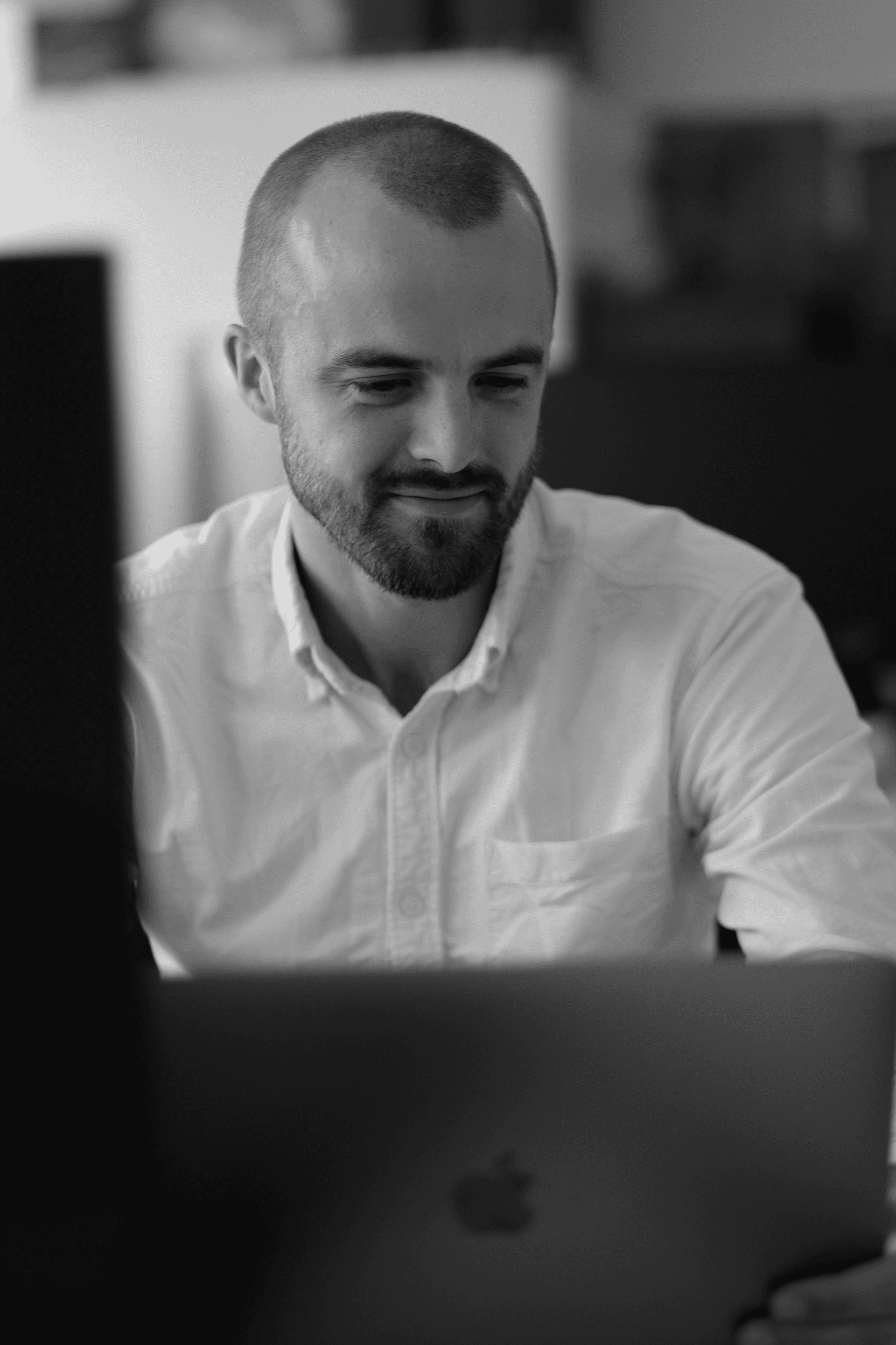 A man in white shirt looking at the screen