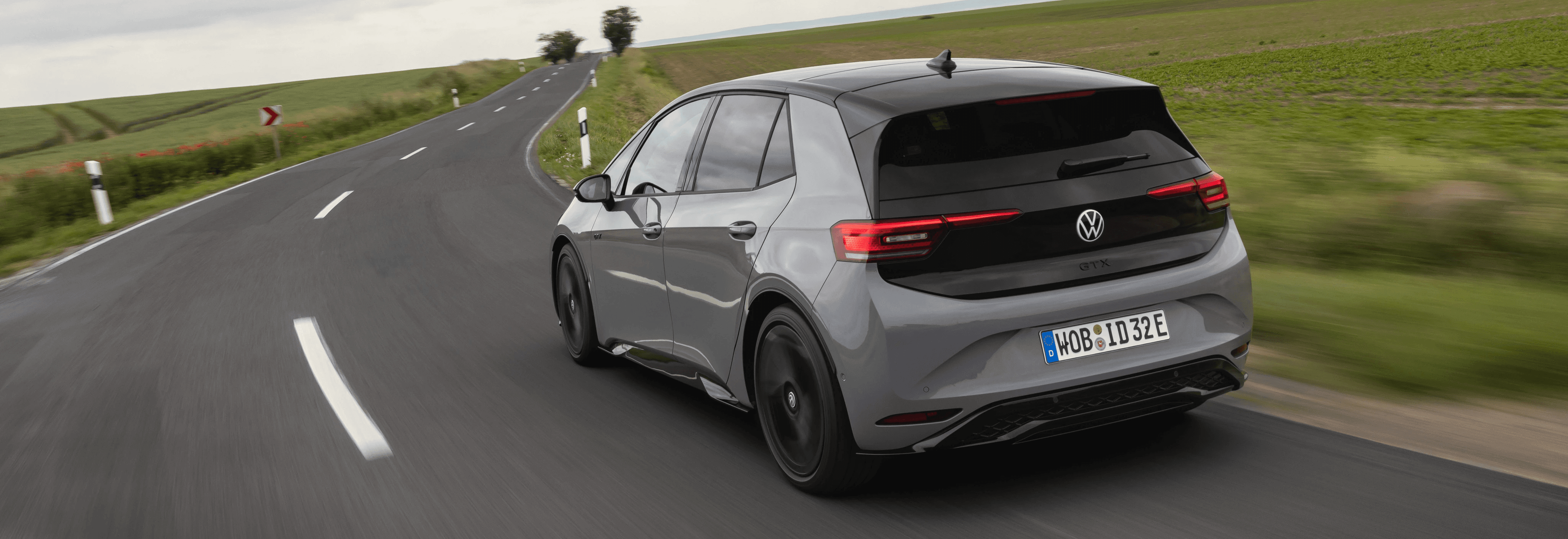 Volkswagen ID.3 GTX grise sur route de campagne, compacte électrique sportive vue de l’arrière