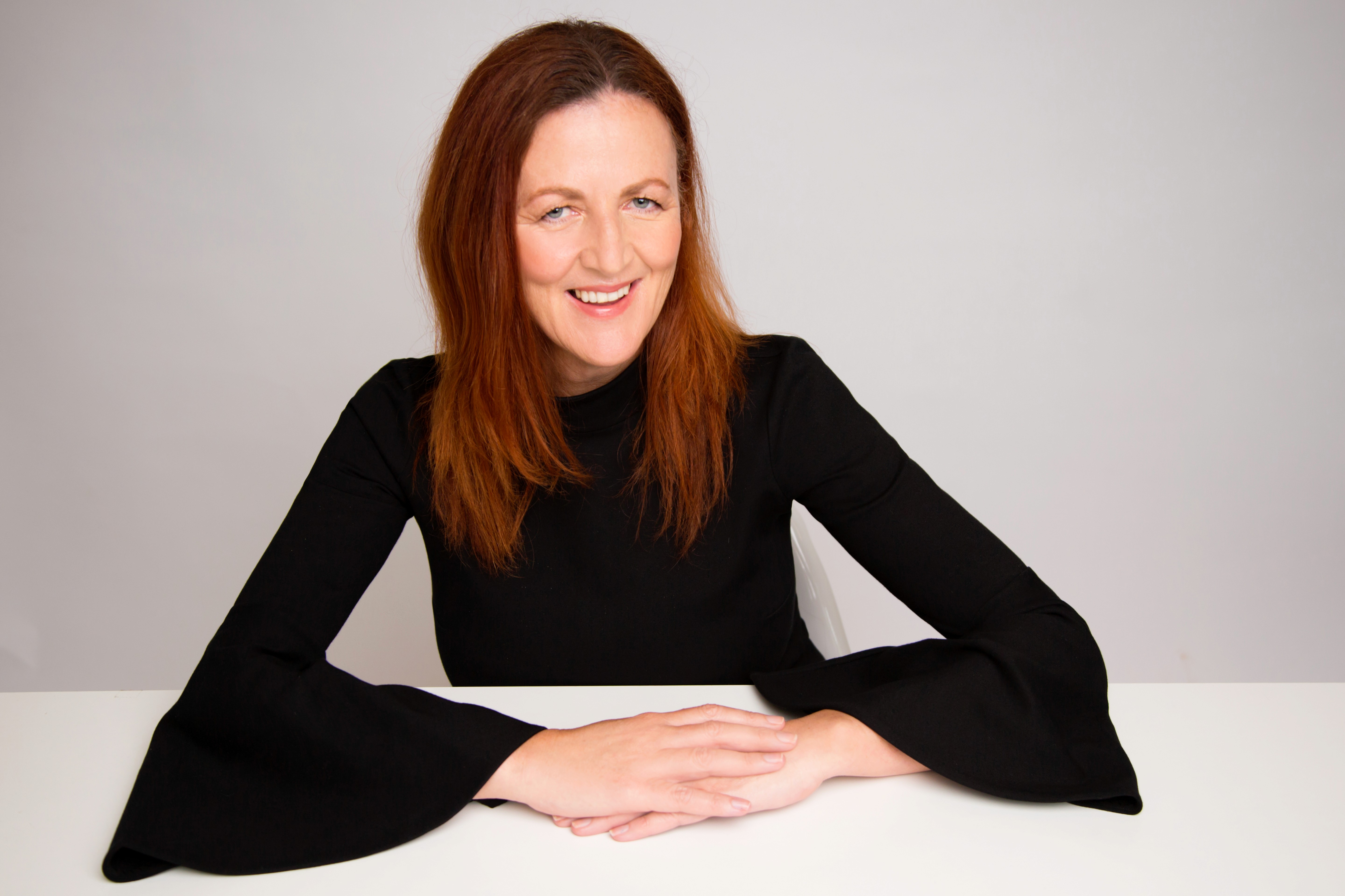 Woman with glasses looking thoughtful and content.