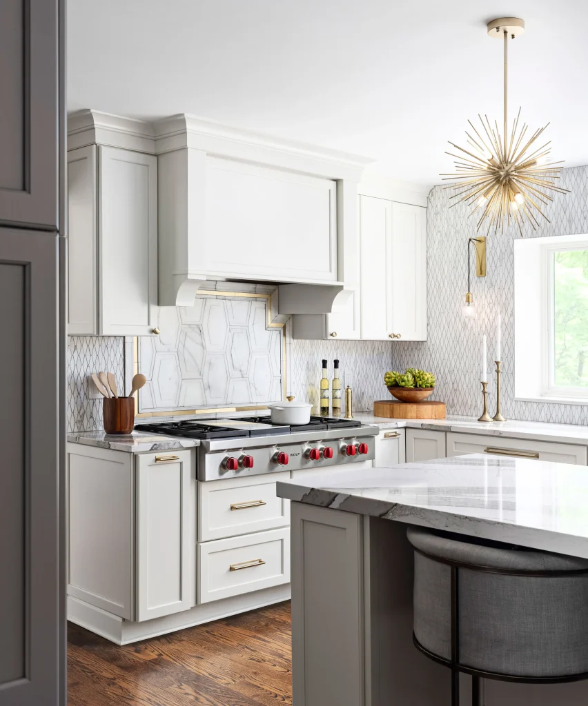 Bright white KSI kitchen with marble island and gold light fixture