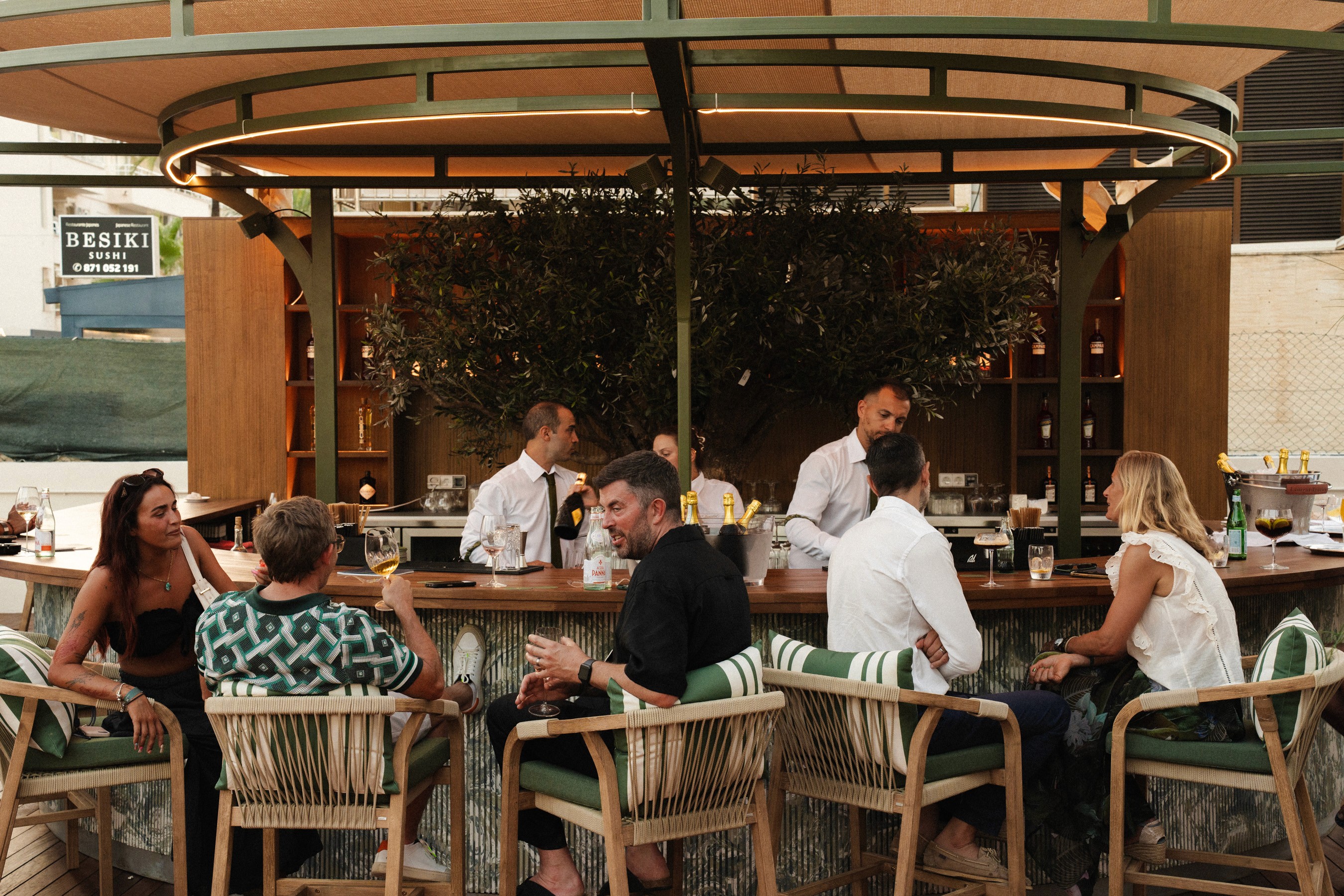 The image presents a serene and modern indoor setting, showing four individuals engrossed in using desktop computers.