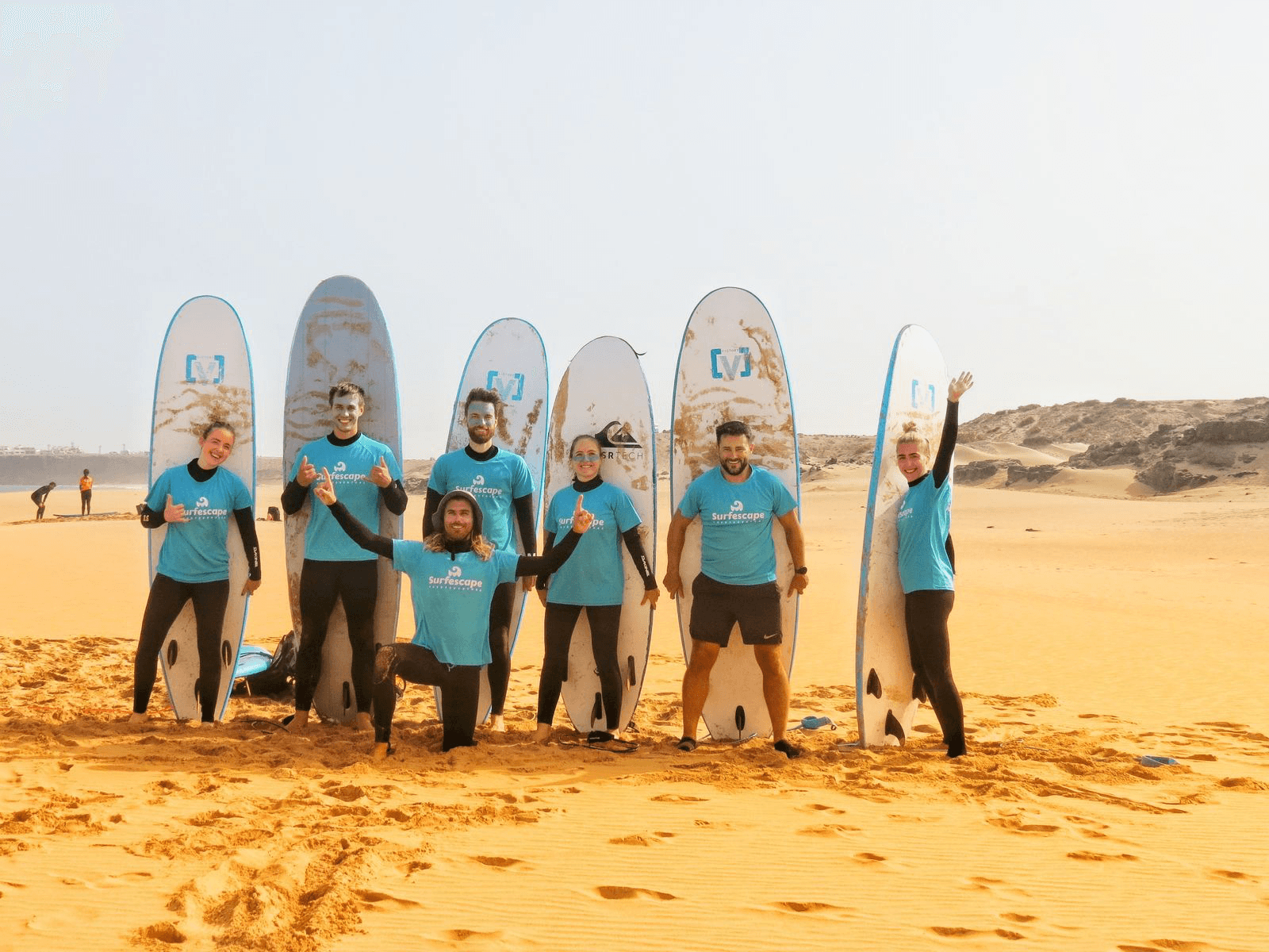 Grupo de surfistas con tablas en la playa
