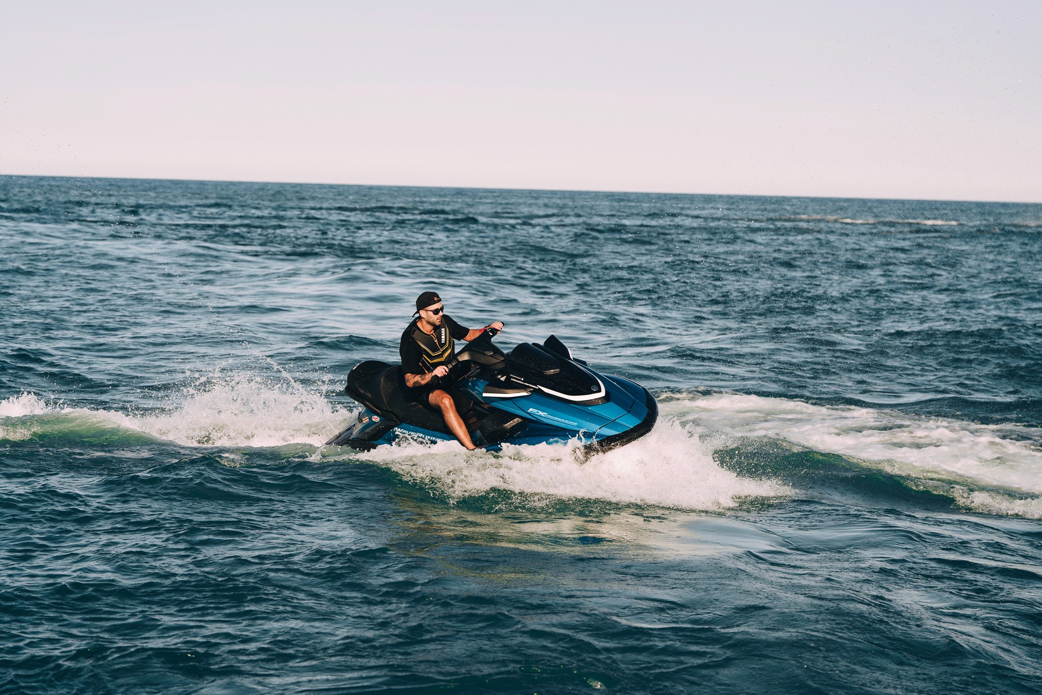 Dark blue Yamaha in dynamic turn with water spray