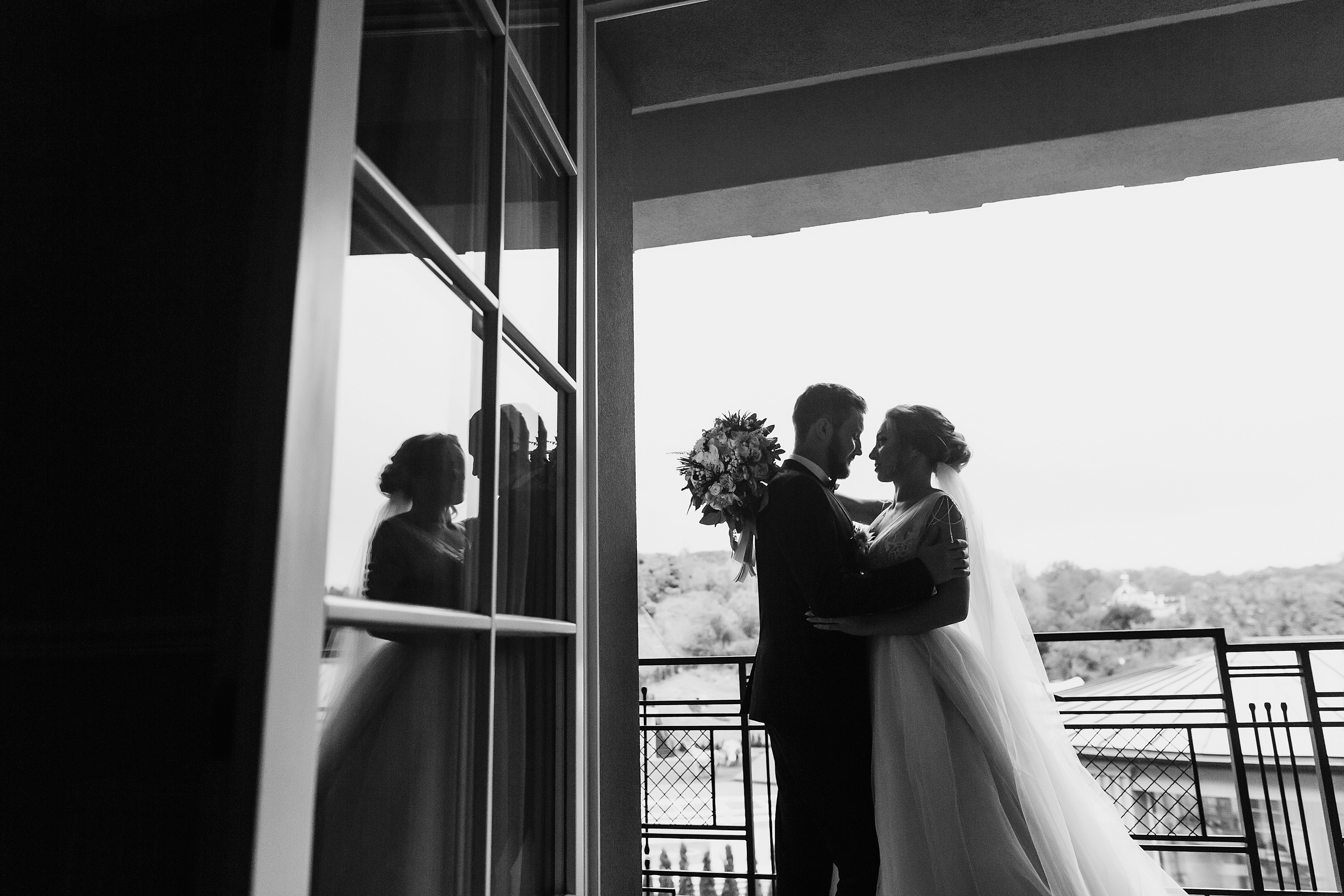 Bride and groom posing for a wedding photo on a hotel terrace.