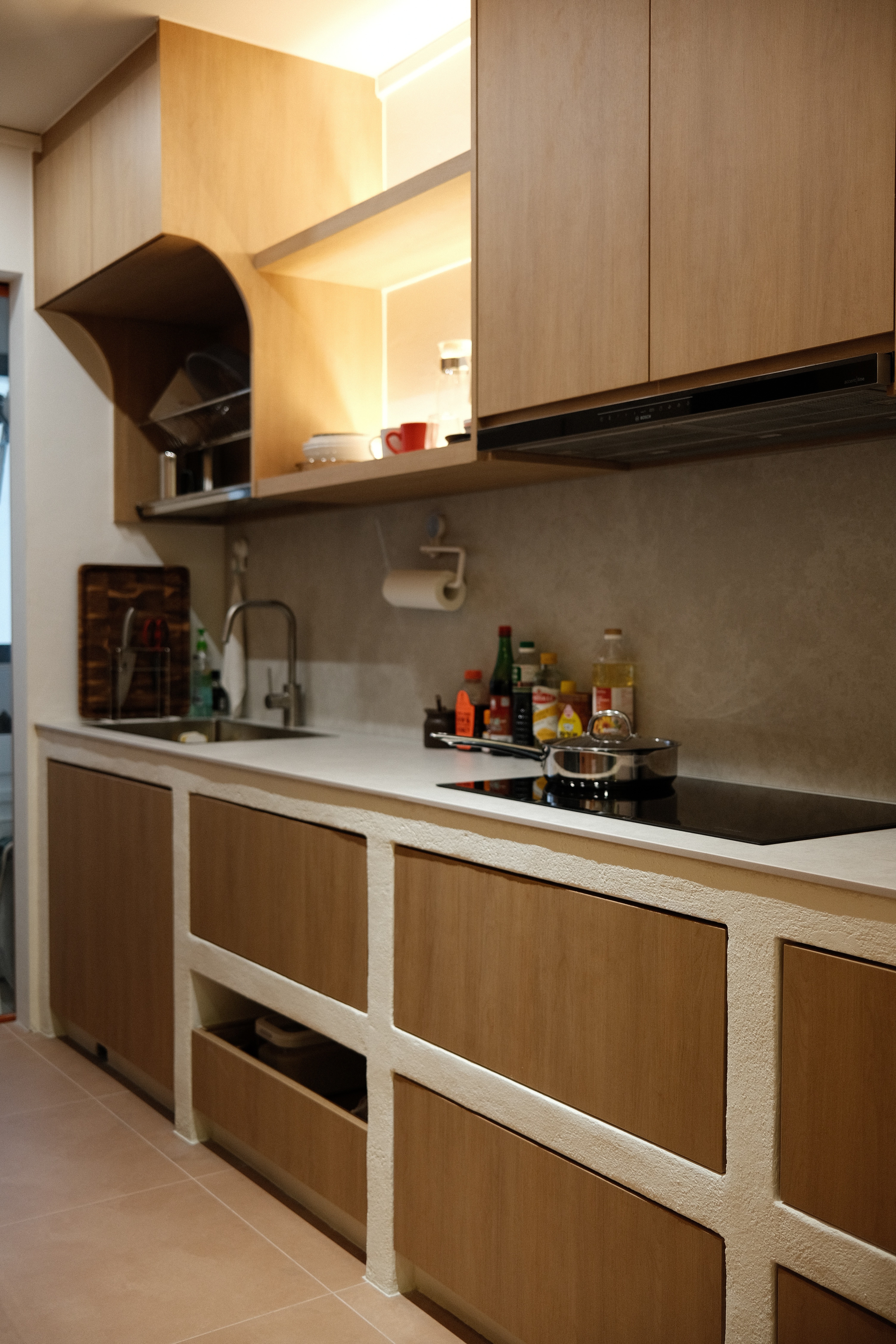 A thoughtfully designed kitchen that balances texture and functionality, featuring warm wood cabinetry, tactile finishes, and integrated lighting for a comfortable, lived-in feel.