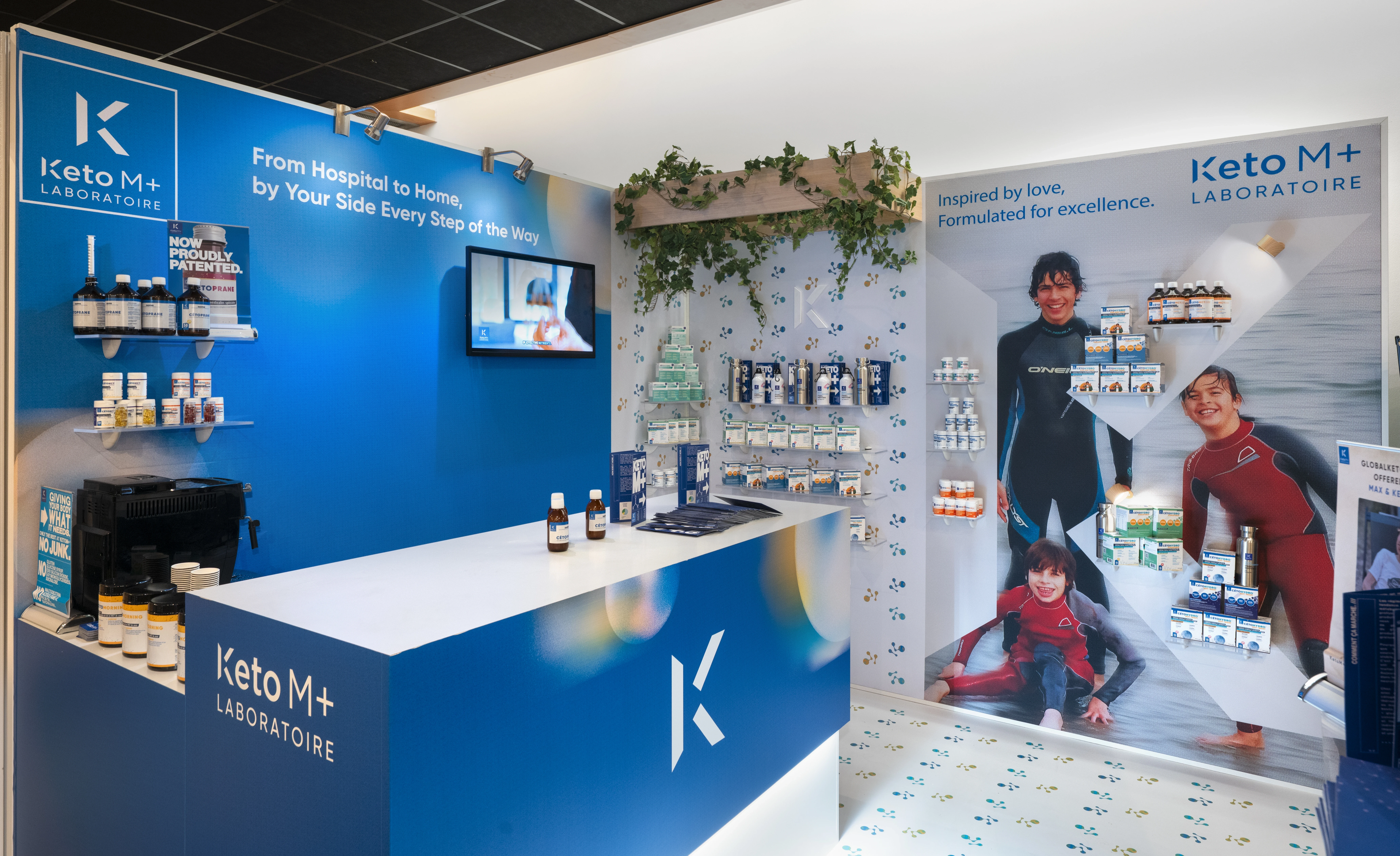 stand Keto M+ Laboratoire au salon Global Keto 2025 à Paris avec comptoir bleu et présentations produits