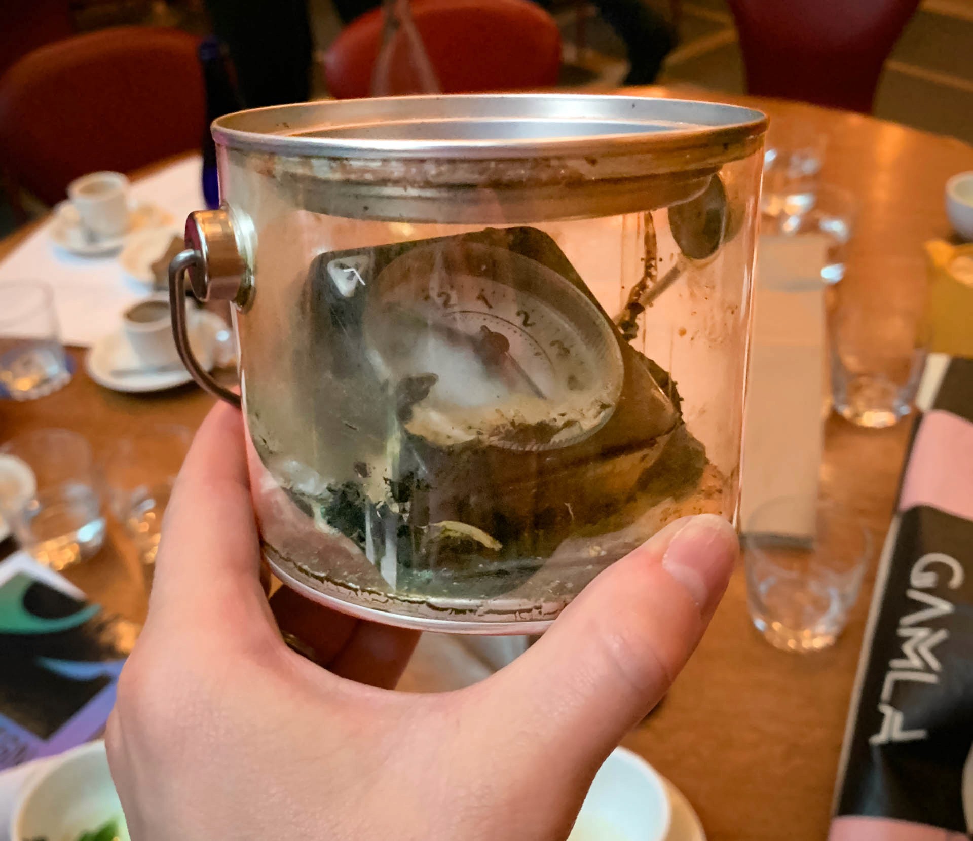 hand holding glass cup with clock inside