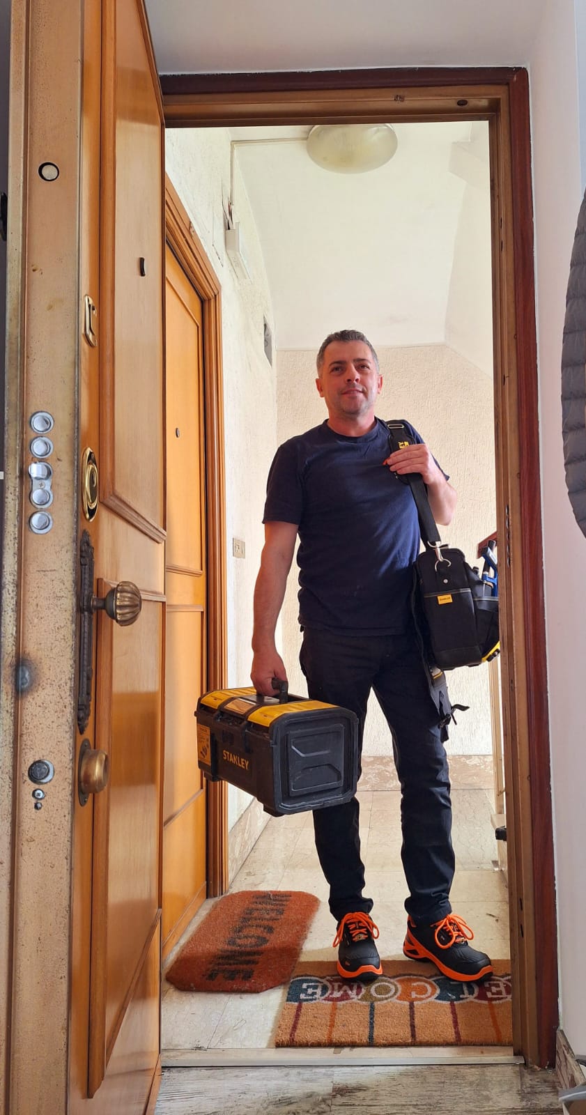 gabriel sulla porta di ingresso con attrezzatura da lavoro idraulica a roma