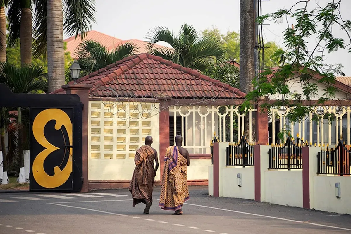 Men wearing traditional kente cloth at a cultural site in Kumasi.