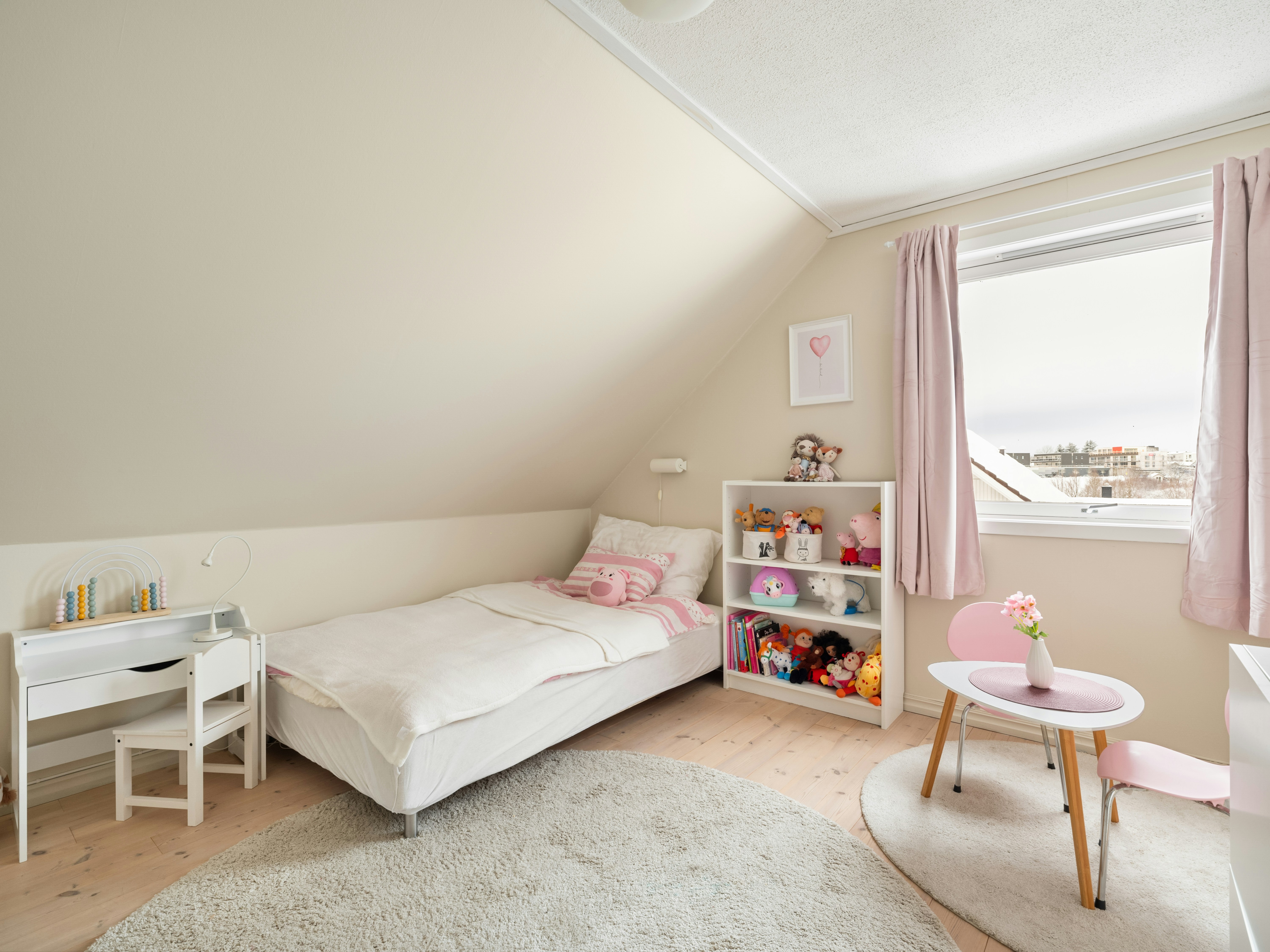 A bedroom with two beds and a desk