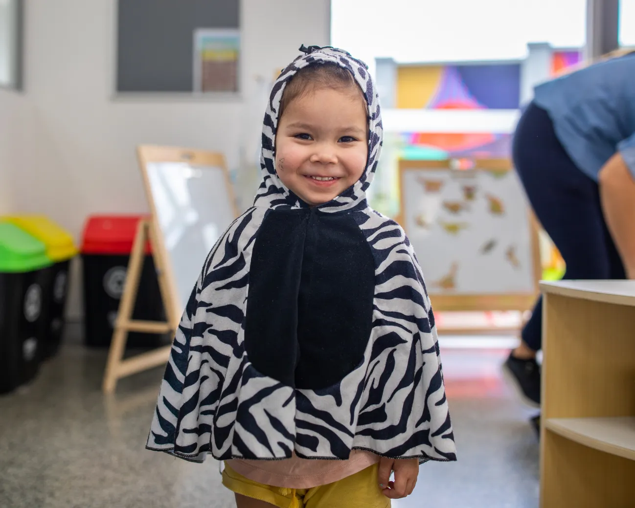 Outdoor play area at Kaleidoscope Kids Redbank childcare centre featuring colourful wall murals, climbing equipment, and shaded learning spaces.