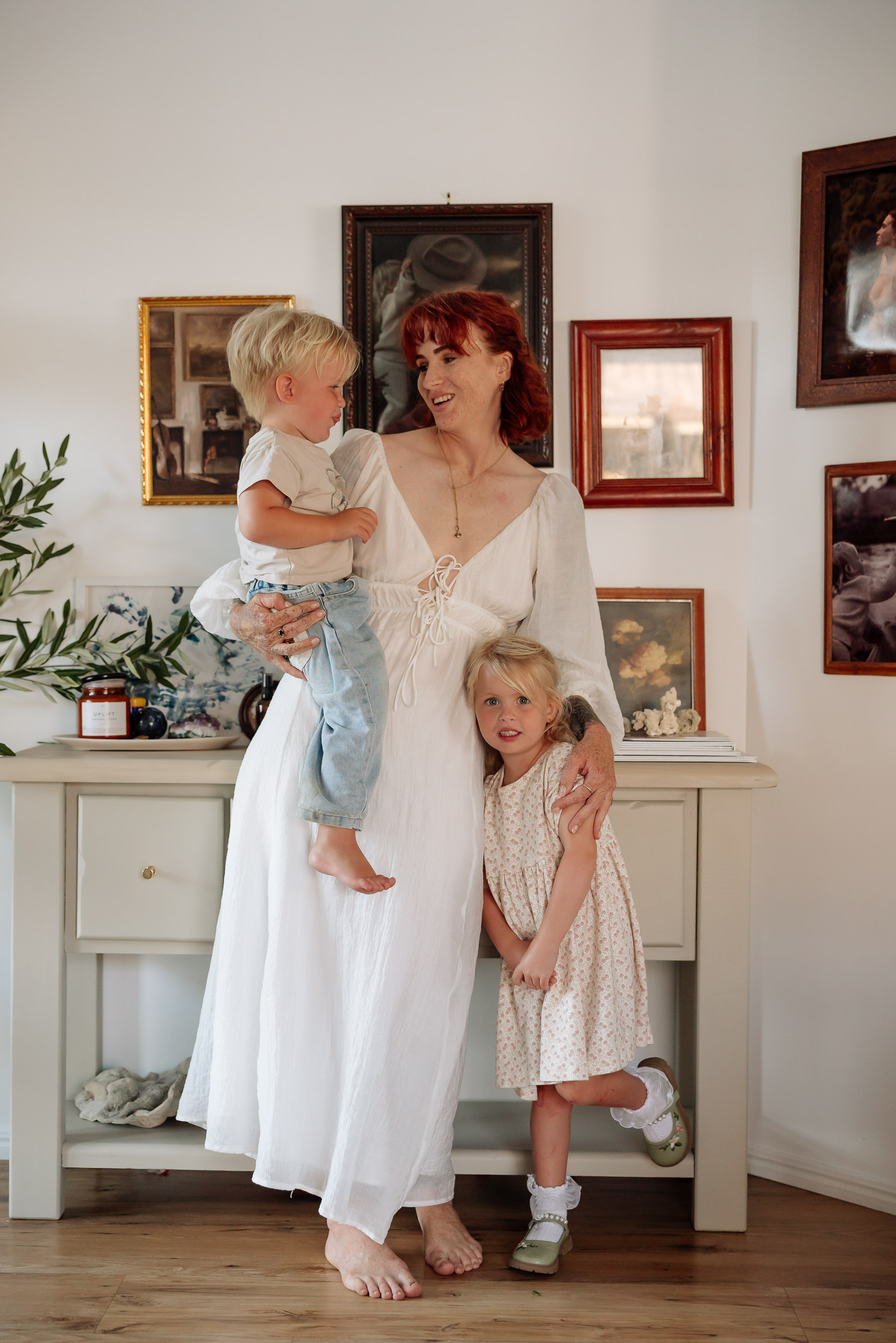 In-home session showing emotional connection between mother and young children indoors in Mackay