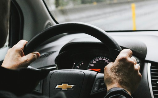 person driving black chevrolet car illustrating driver licence