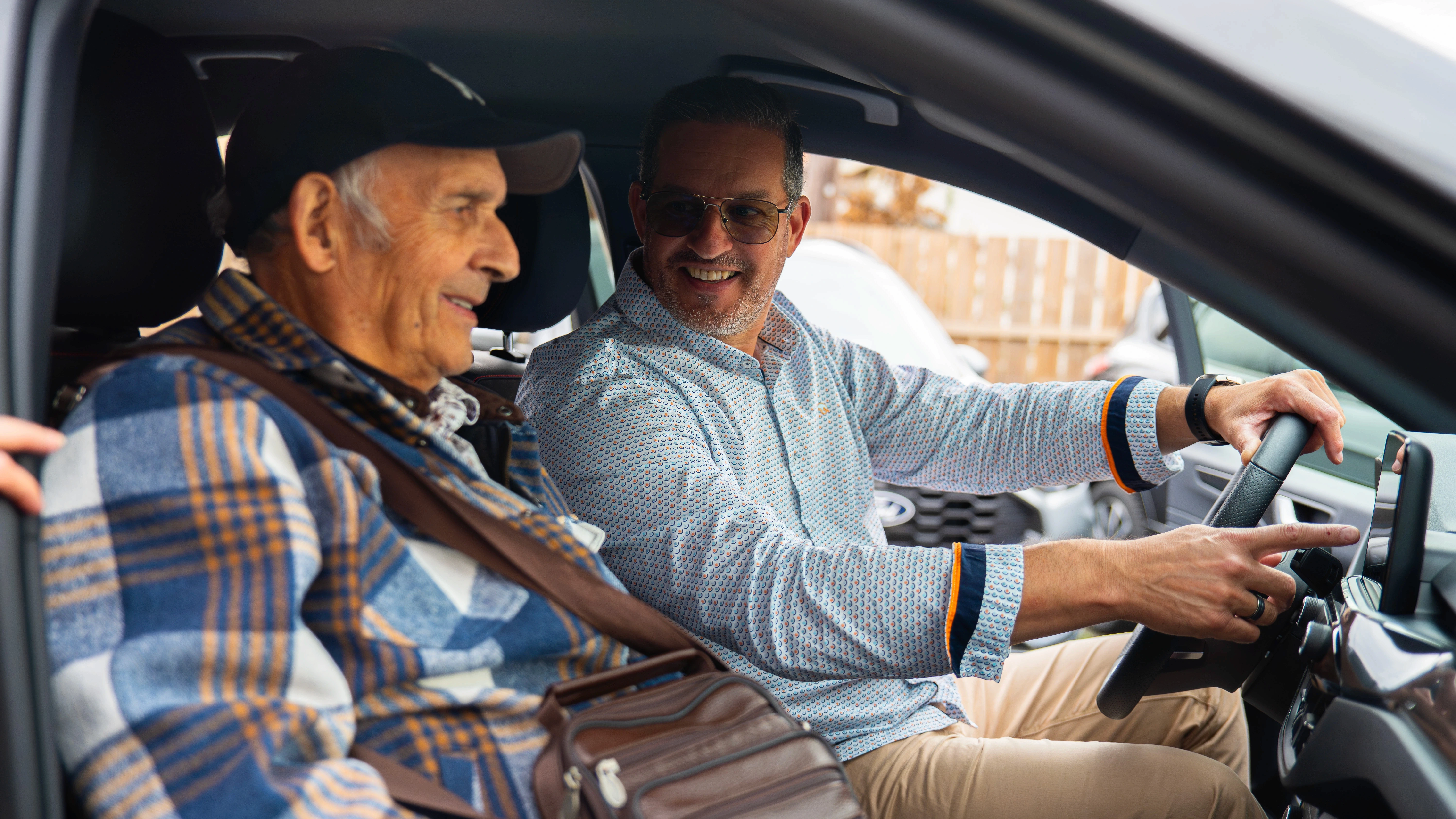 Client senior accompagné par un conseiller d’Automobiles Andreu lors d’un essai de voiture d’occasion, concession automobile de confiance dans le sud-ouest