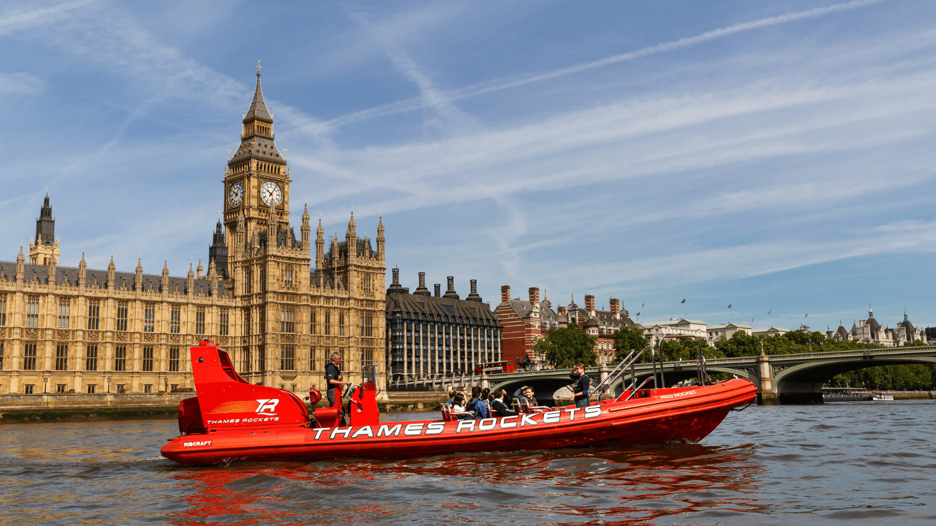 Thames Rockets Speedboat Experience: The sleek red Thames Rocket RIB speeds in front of Big Ben and the Houses of Parliament.