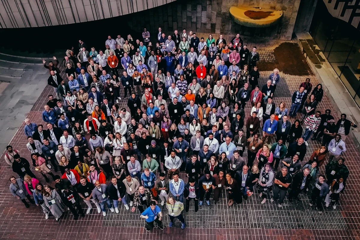 Arial photo of a large group of the Opencast team standing together smiling at the camera