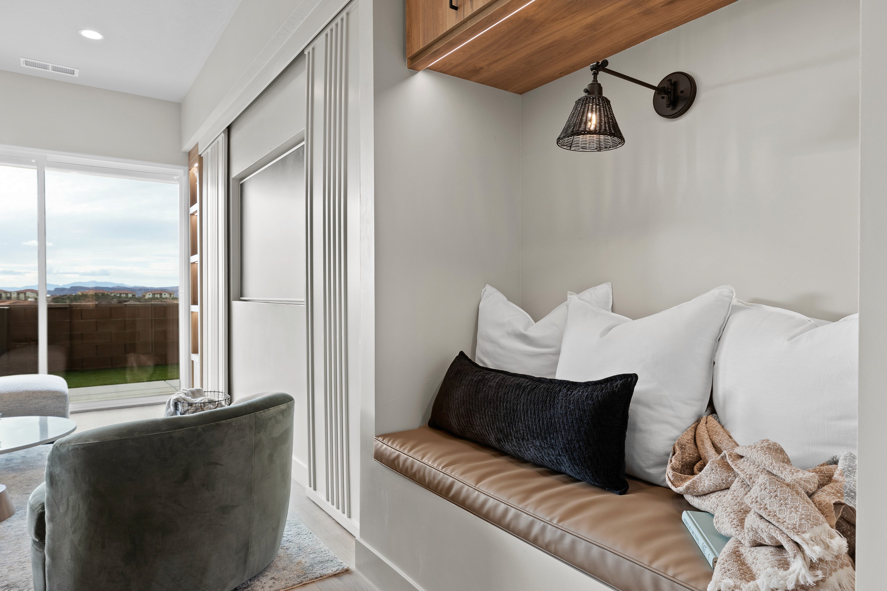 31. Built-in bench and entertainment center in the great room of the BYSO House in Hurricane, Utah, providing seating and storage in a bright, open living space.