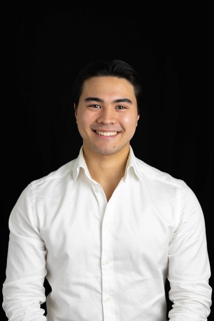 Portrait of a person in dark clothing speaking on a phone