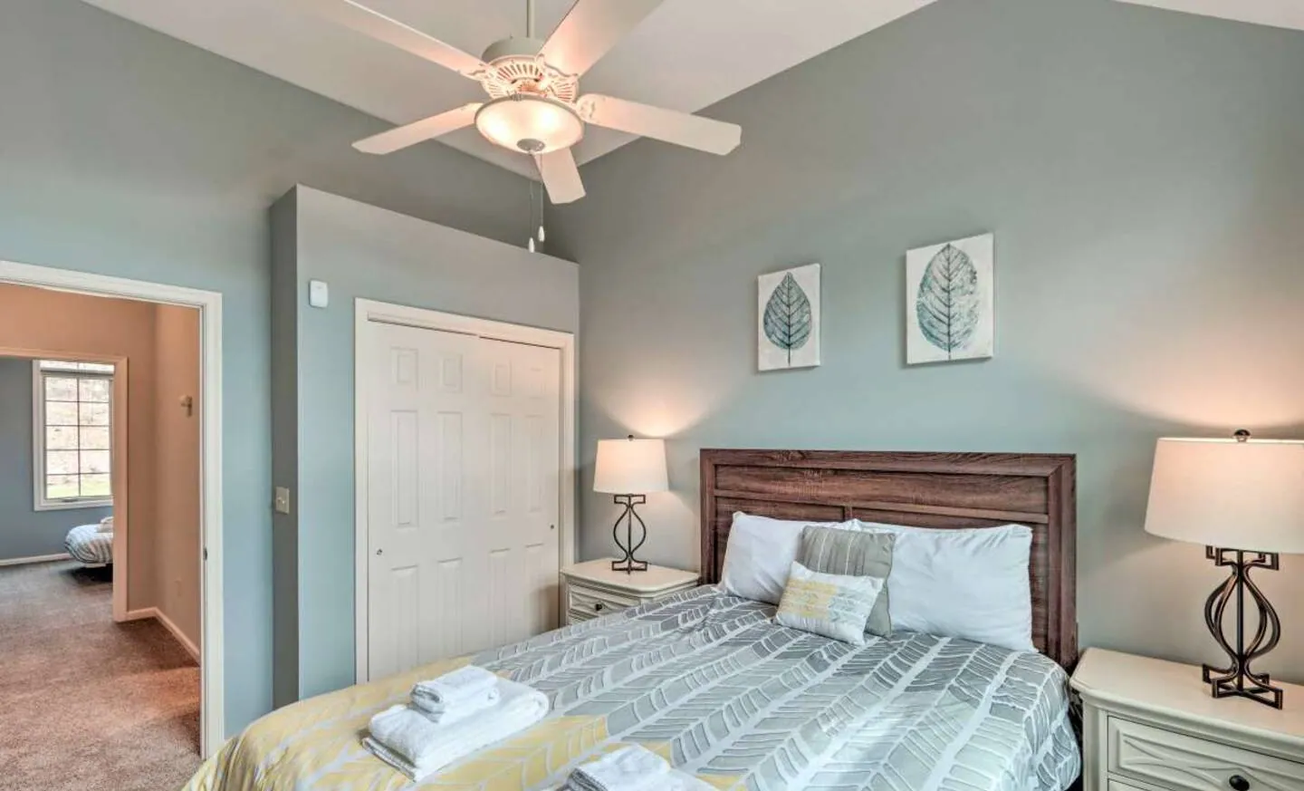 Queen bed with yellow and white bedding and nightstand lamps at SummitWind