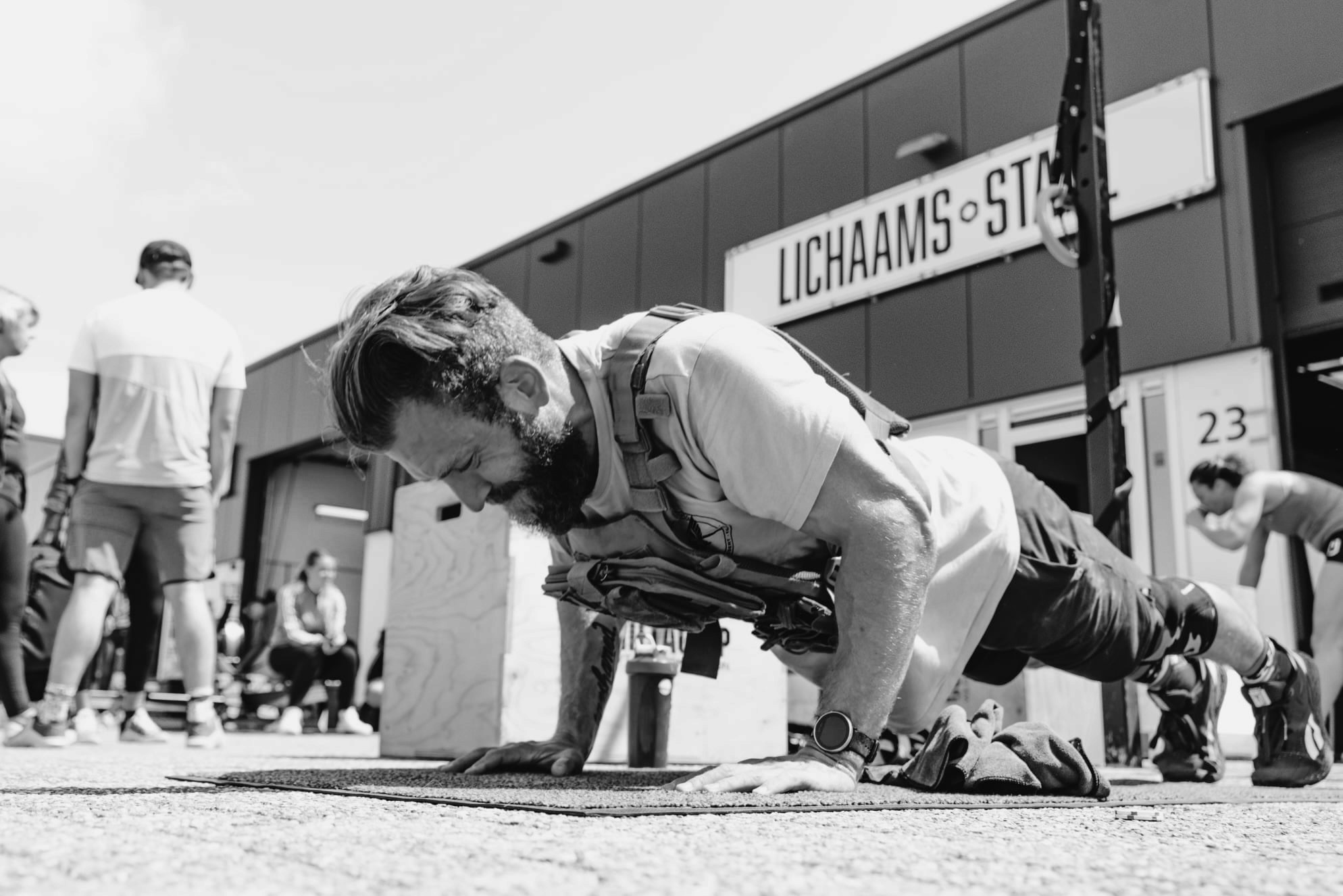 A man doing push-ups wearing a weightvest