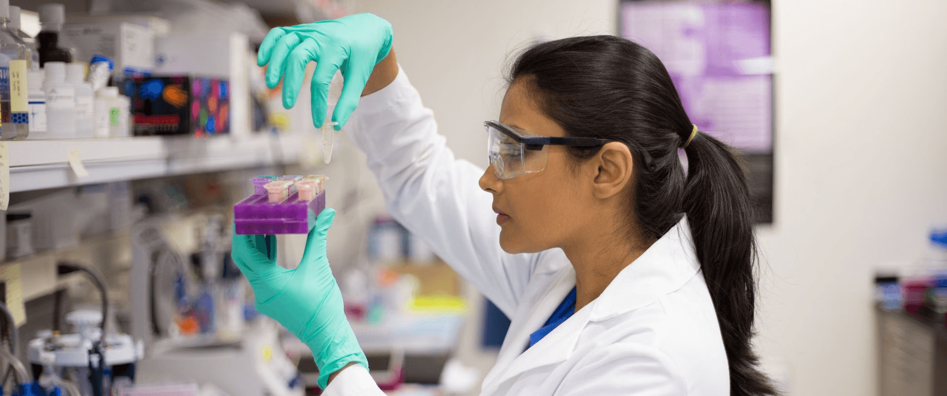 Researcher examining samples under a microscope, overlaid with DNA and molecular structures representing genetic research