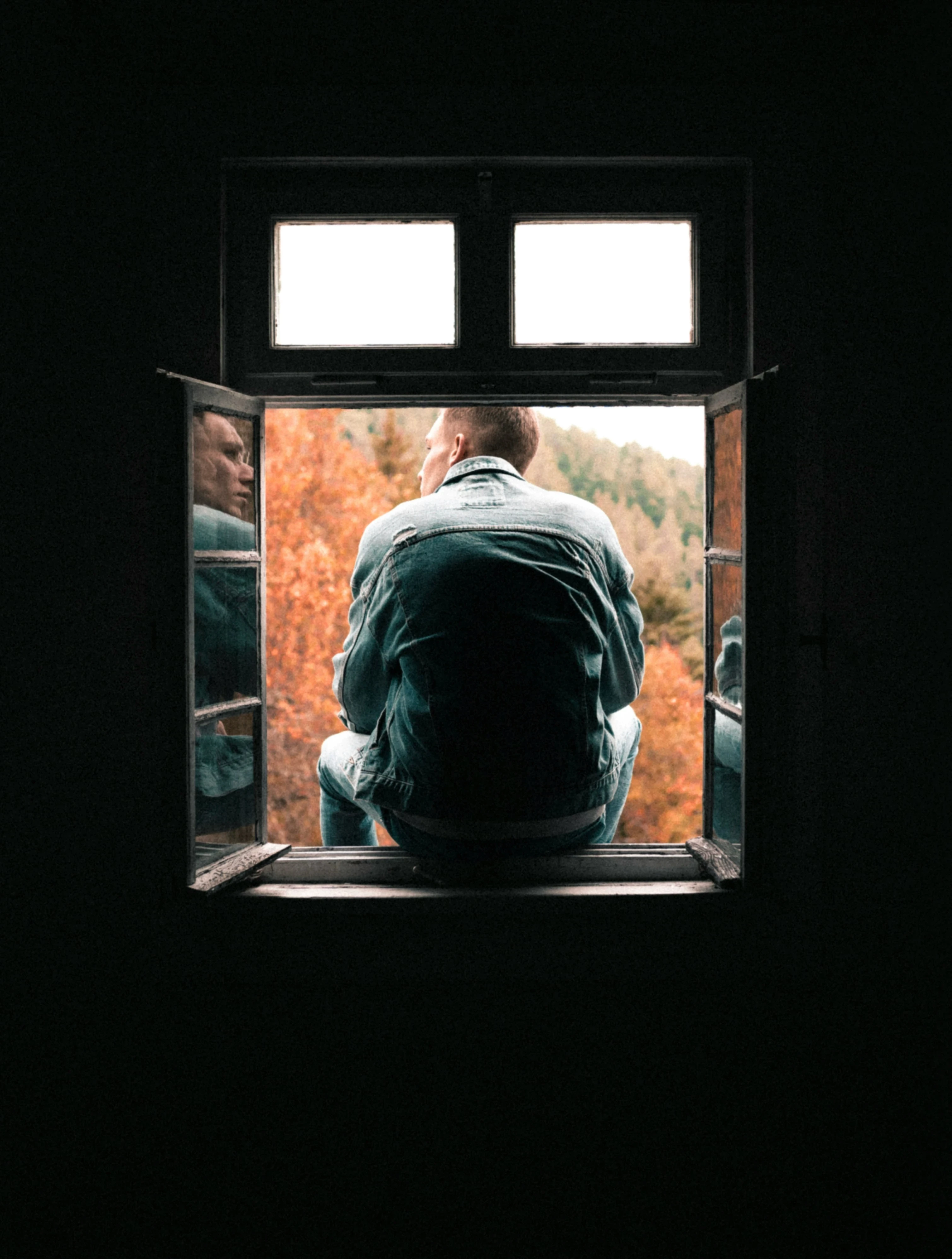 Man sitting alone by a window, symbolizing male loneliness, emotional isolation, and introspection