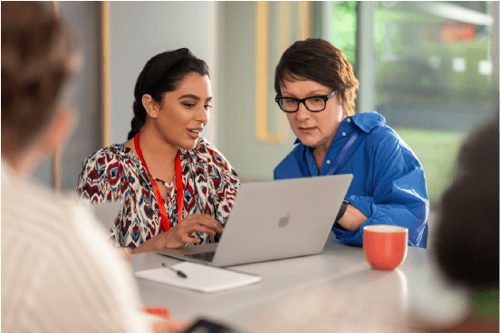Zwei Lehrkräfte bei einer praxisnahen Fortbildung am Laptop in einem hellen Arbeitsraum