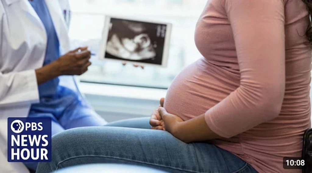 woman in black half-sleeved shirt sitting while facing woman and smiling