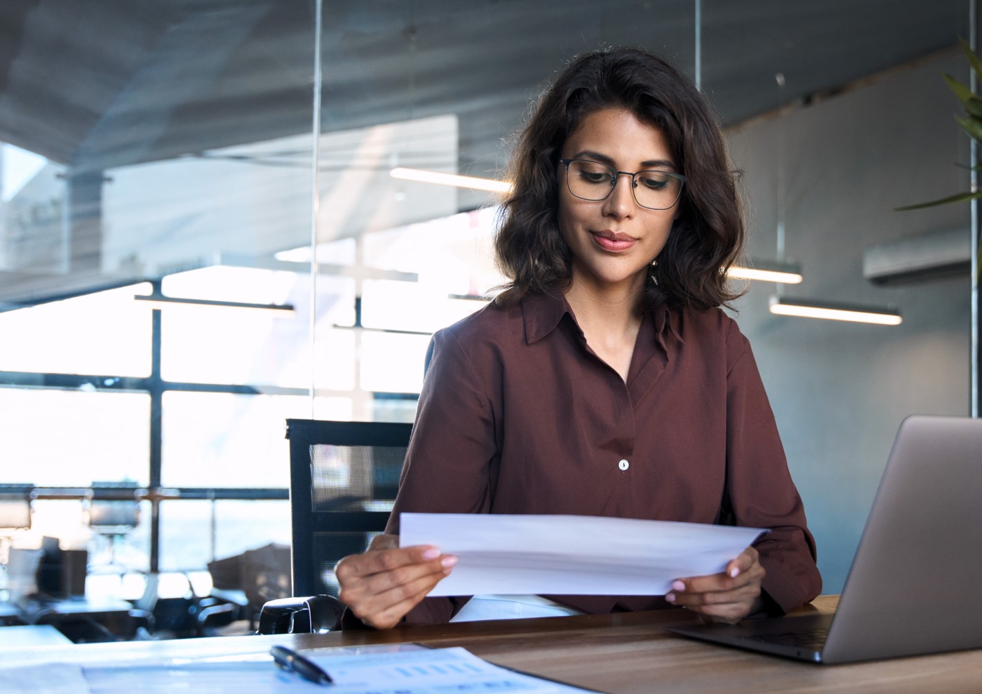 A lady checking a document as part of payroll management in the company.