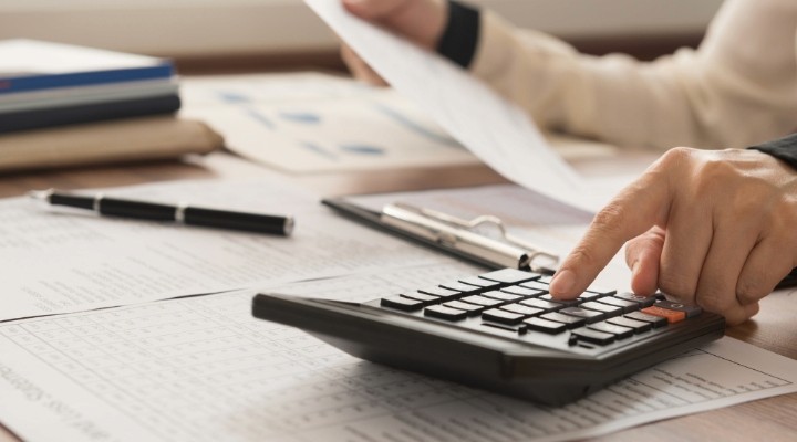 healthcare practitioner calculating finances for 2024 with a calculator