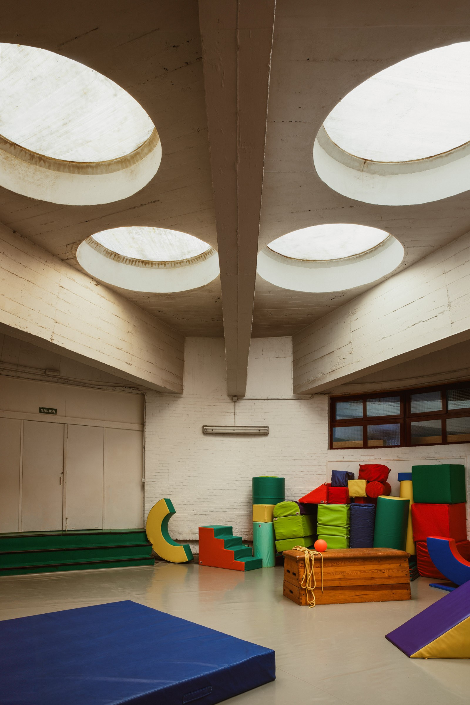 Gymnasium with circular skylights at Los Círculos de Oíza school