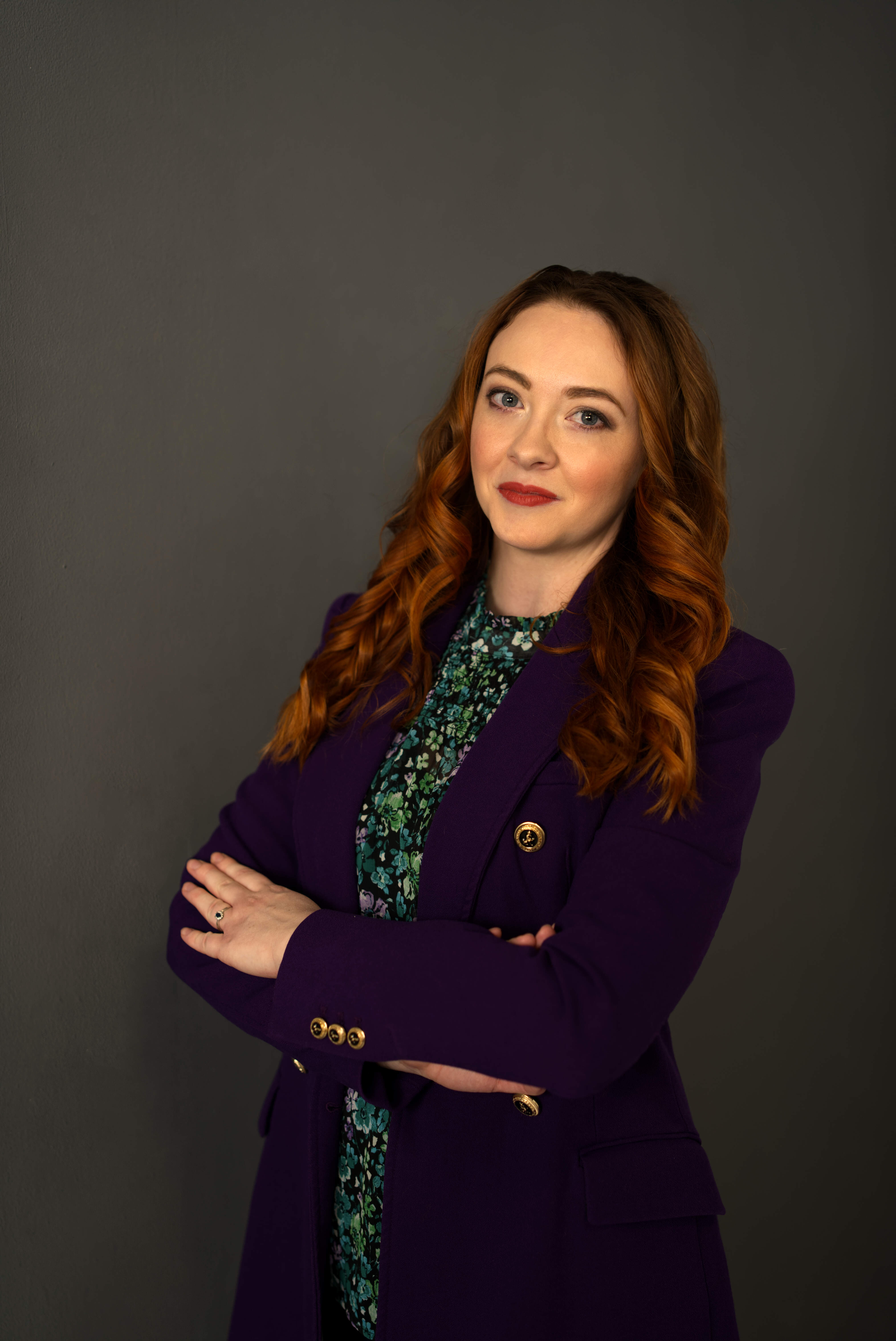 Professional headshot of a person in a formal setting.