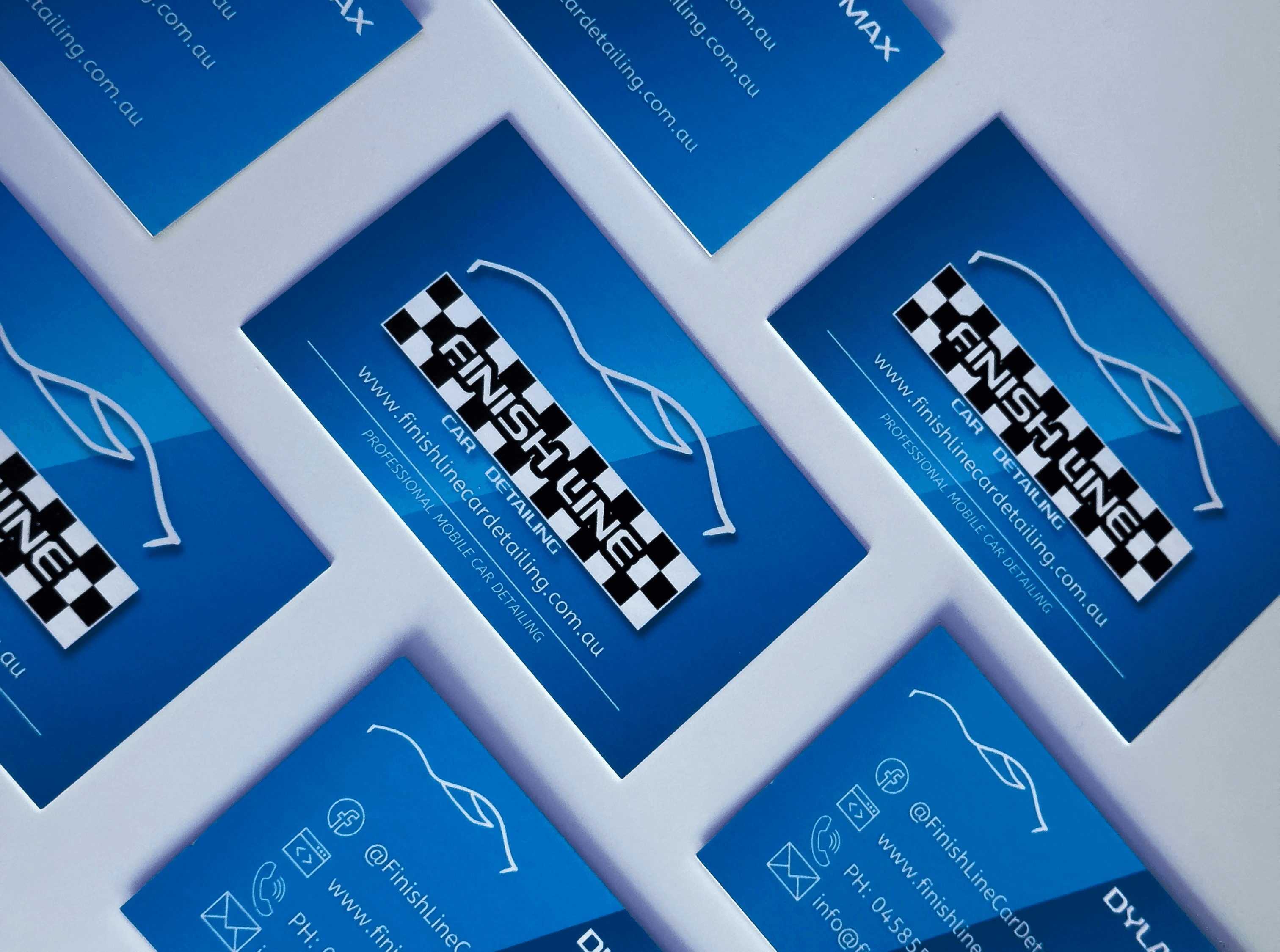 Photo of business cards designed for Finishline Car Detailing, a portfolio project by Dylan Coleman, featuring a sleek and professional layout with the logo prominently displayed.