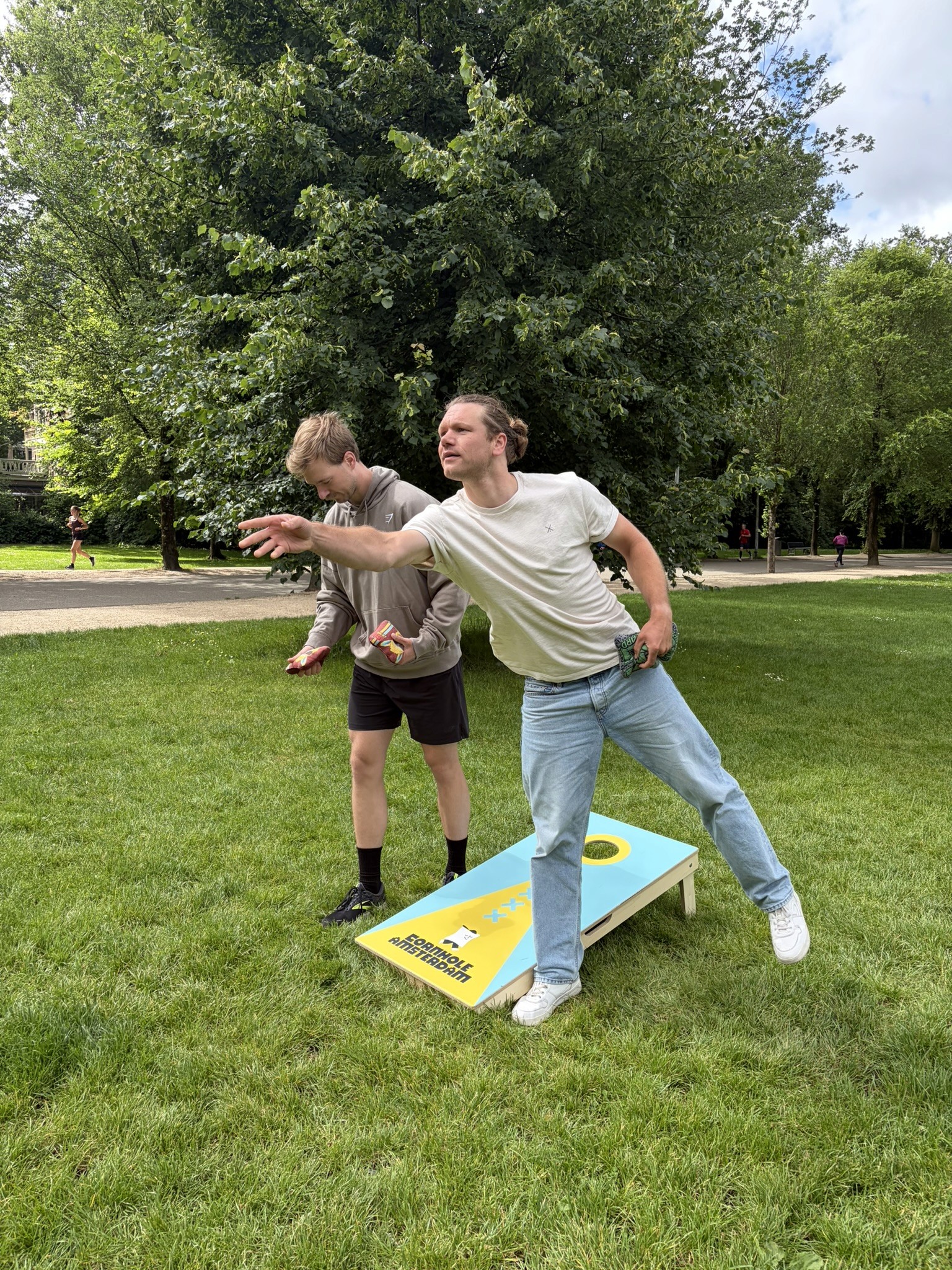 Twee spelers tijdens een gratis cornhole parksessie in Amsterdam