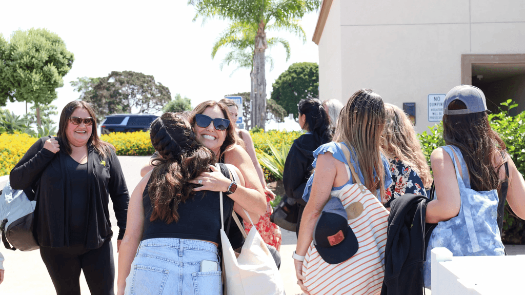 office employees hugging and greeting at team building event