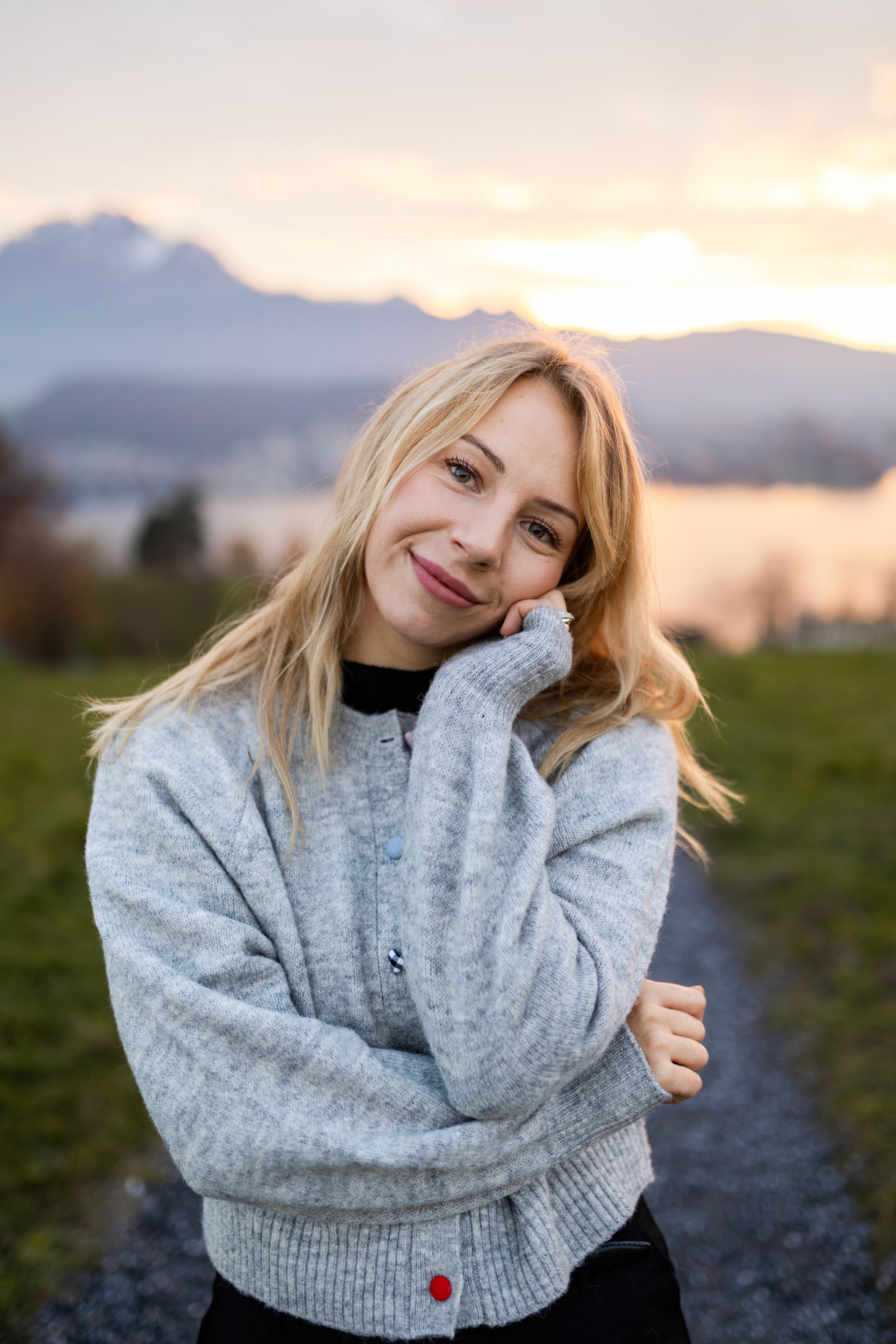 Smiling blonde woman in a knit sweater at sunset