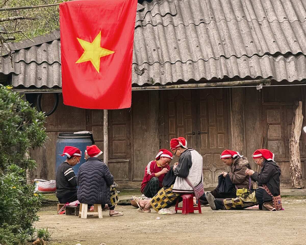 Red Dao women gathered outside a traditional house in Ta Phin village near Sapa, Vietnam.