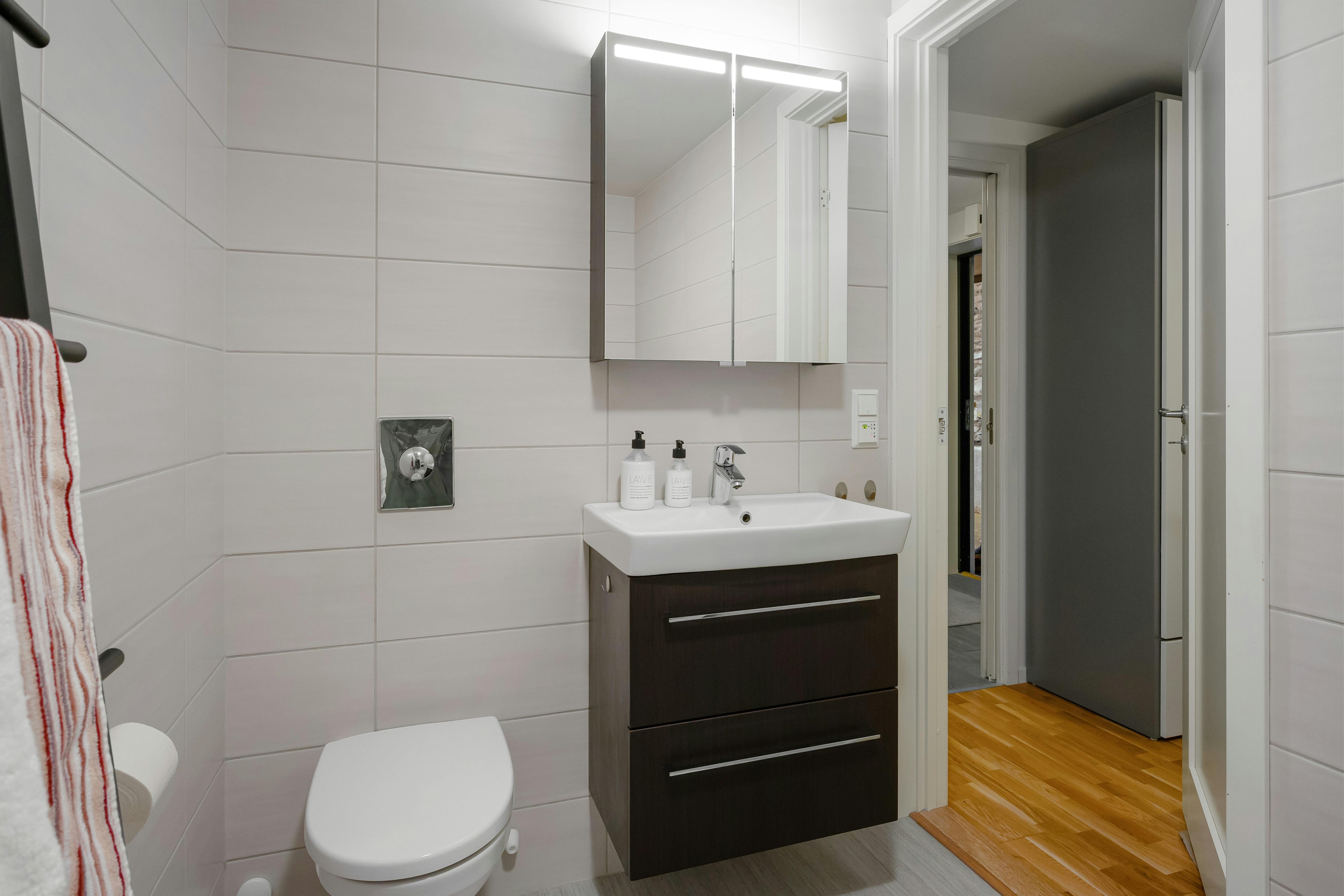 A bathroom with a toilet, sink and mirror