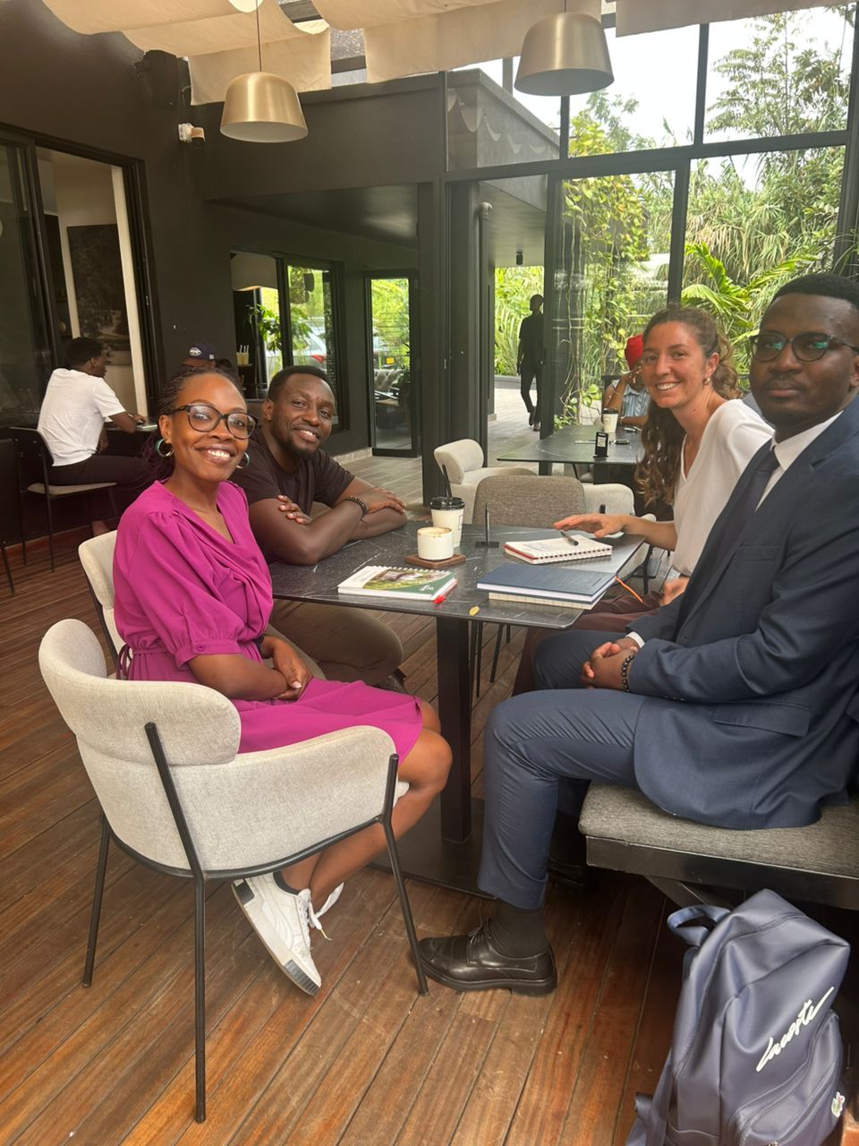 A winding road cuts through rocky terrain, surrounded by patches of green grass and illuminated by sunlight.