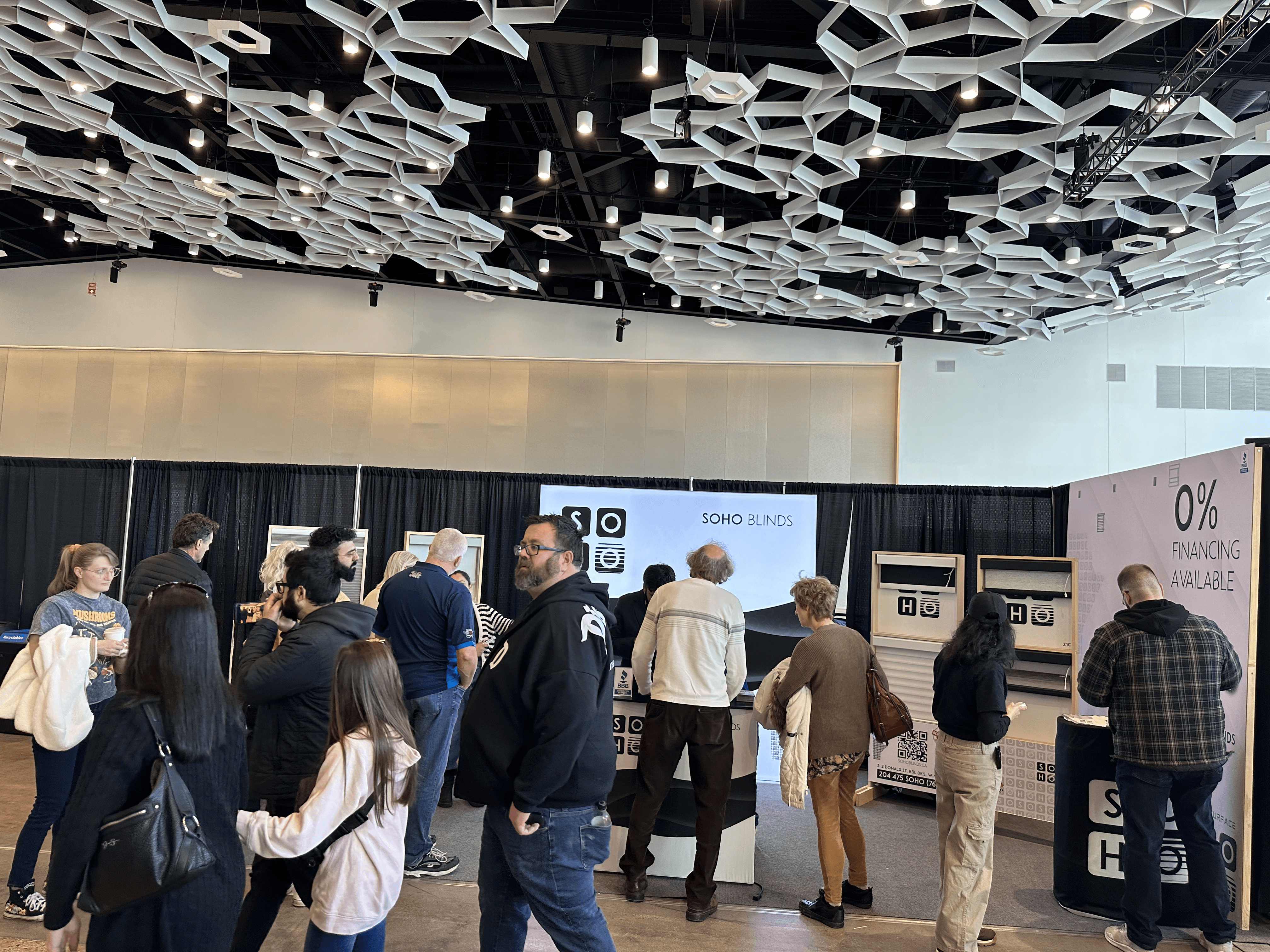Modern red brick apartment or office building viewed from below against a blue sky, showcasing its geometric architecture with evenly spaced windows and balconies.