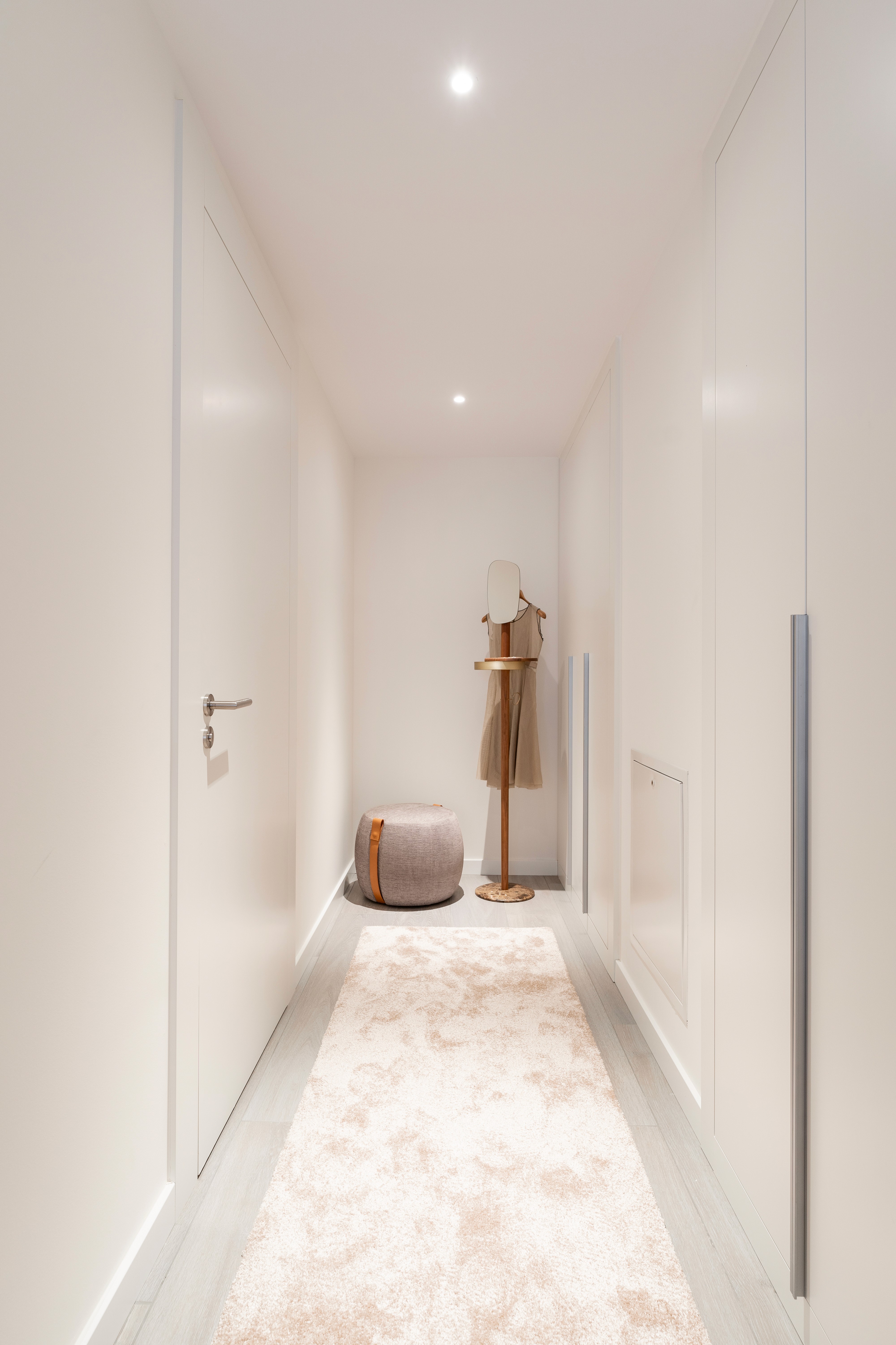 Zona de vestidor con muebles de acabados blancos