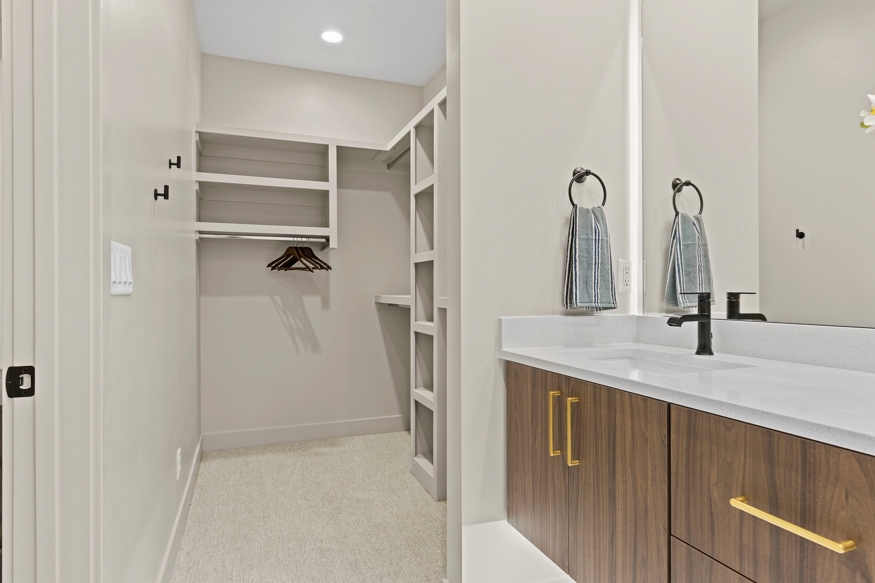 Walk-in closet connected to the primary bathroom in The Painted Horizon twin home in Hurricane, Utah with built-in storage.
