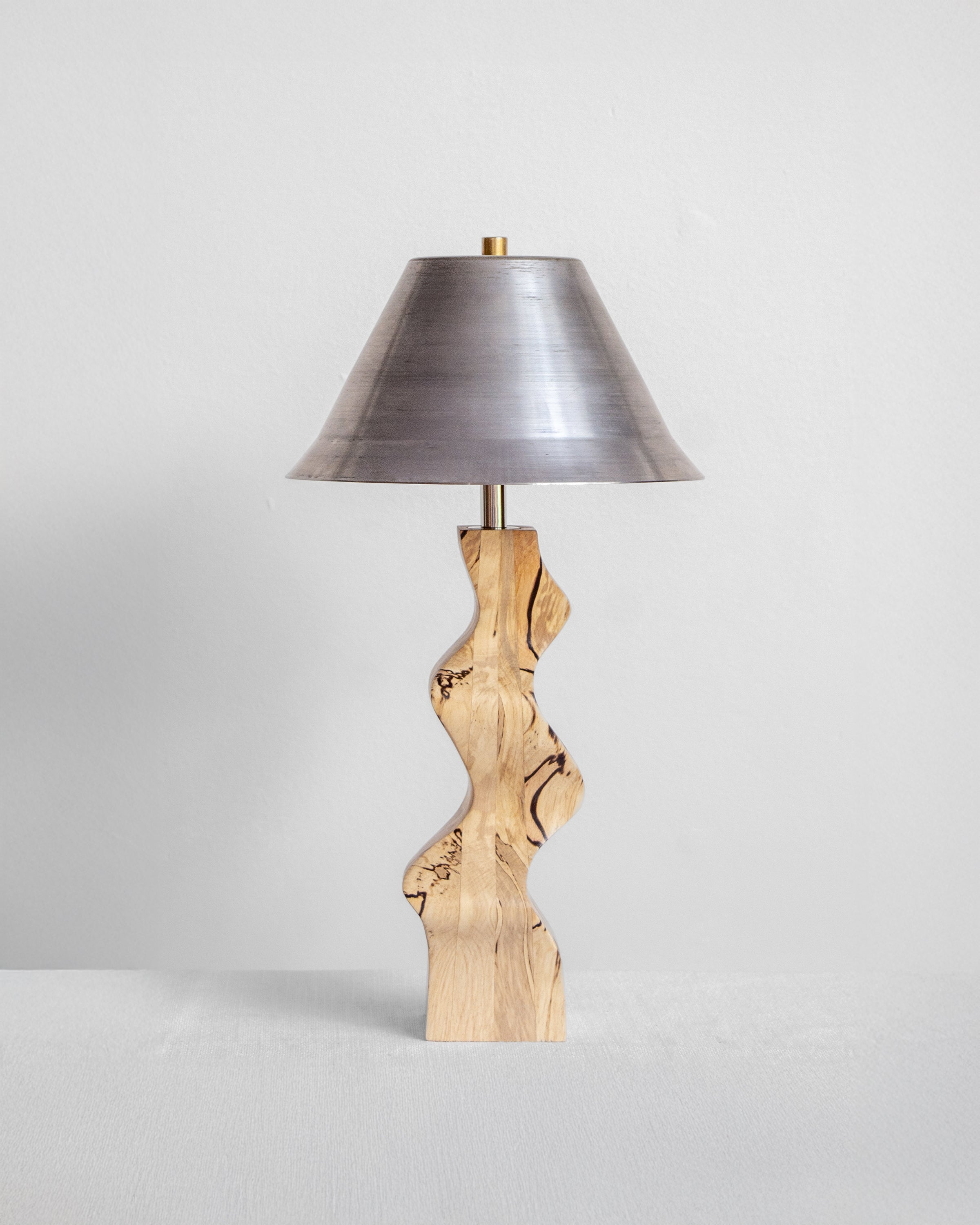 Rippled Desk Lamp with Spalted base and Raw Steel shade on a light grey background with UK, EU and US/CA wiring available on white background Wilkinson & Rivera