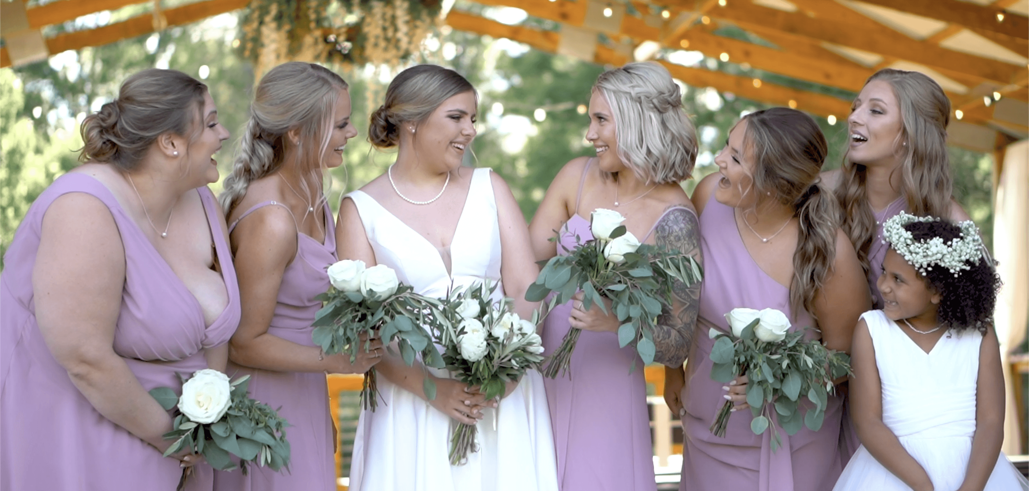 Bridal photo featuring 6 people all all smiling at a bride on her wedding day.