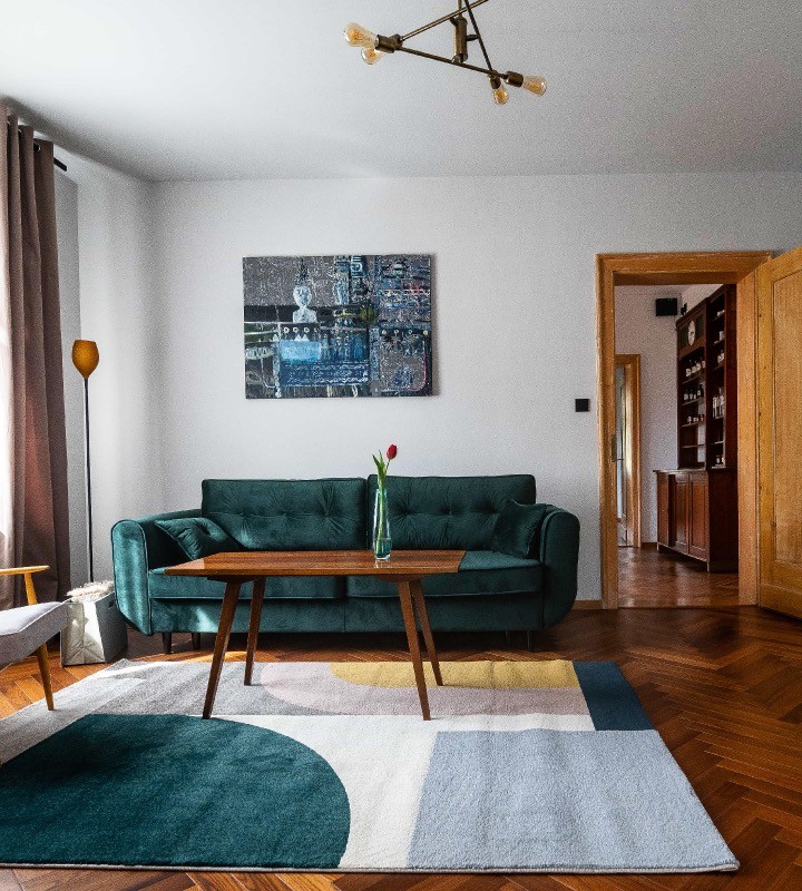 Zielona sofa i obraz w apartamencie w Villa Stara Apteka. Noclegi dla grup na Dolnym Śląsku w Srebrnej Górze